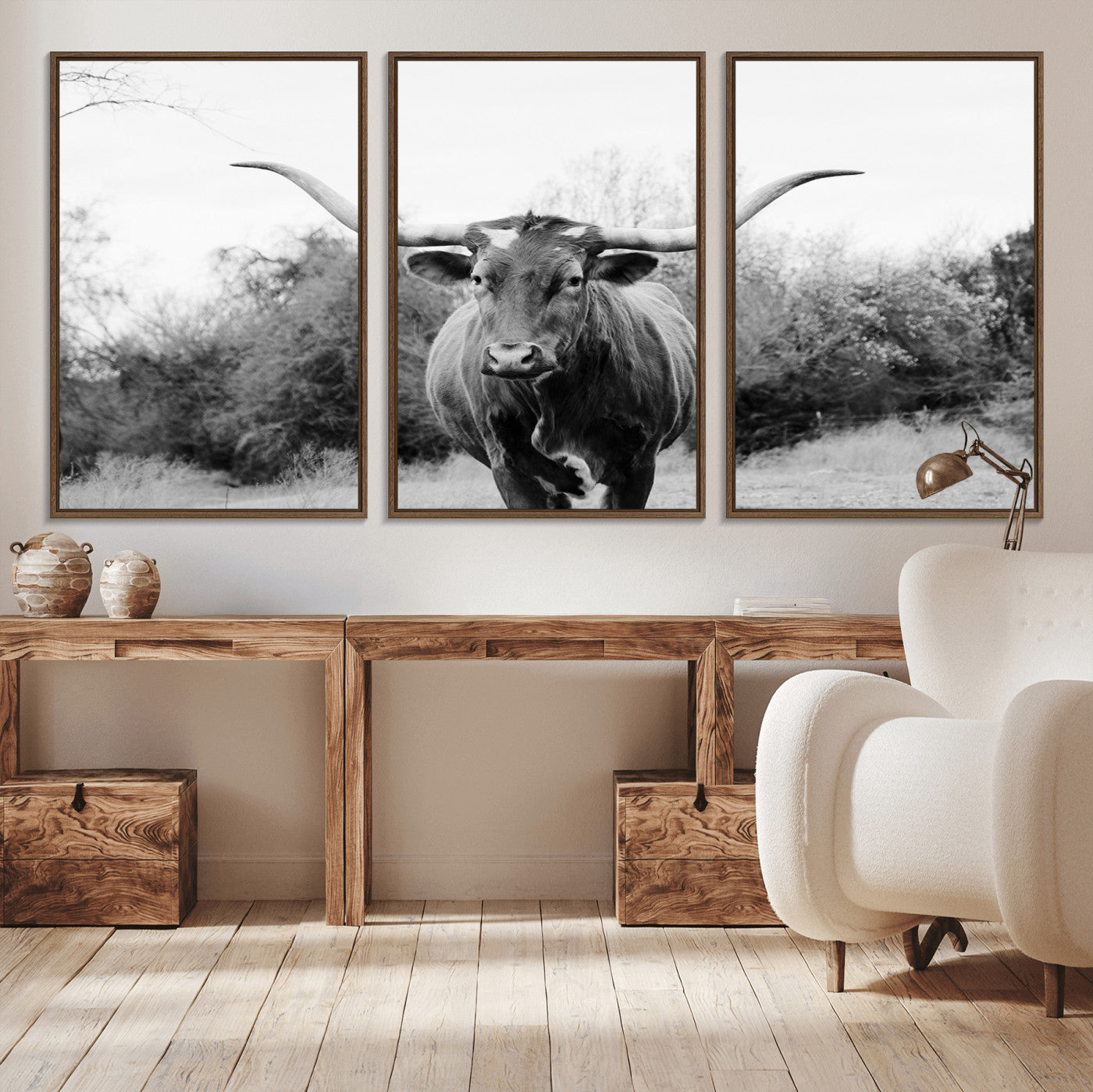 Black and white photo of a longhorn cow in a field, perfect for rustic farmhouse or western-themed interior wall decoration.