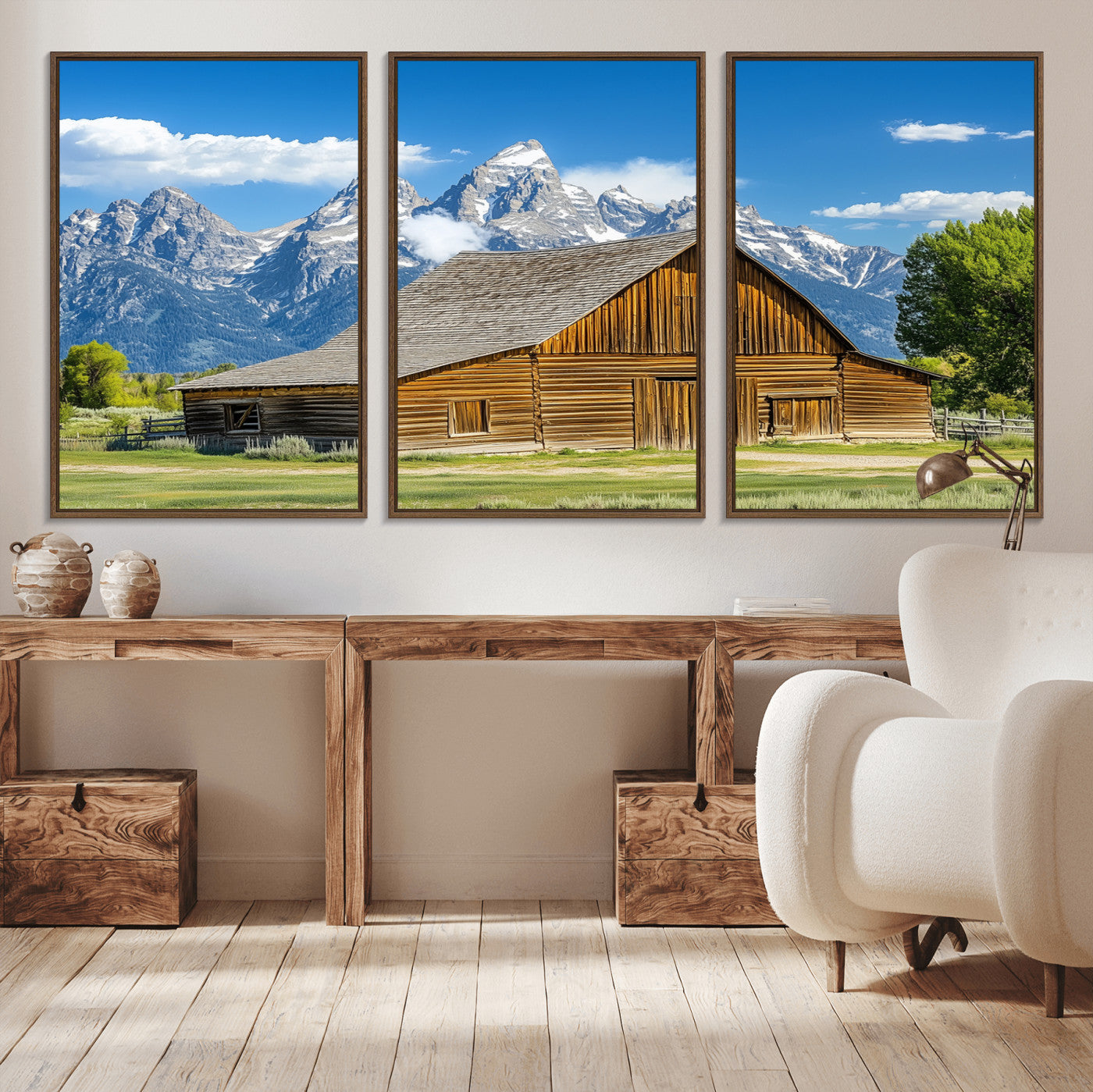 A rustic wooden barn sits in front of towering mountain peaks under a clear blue sky, perfect for farmhouse or cabin style interiors.