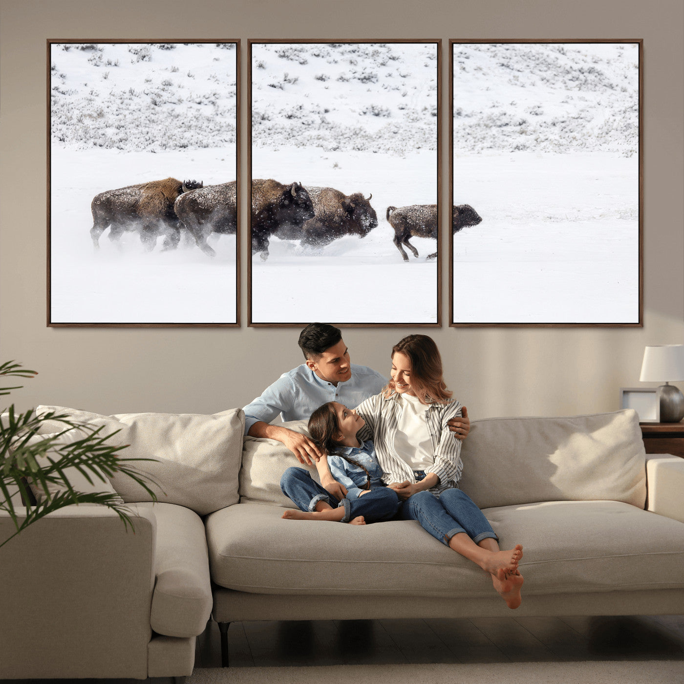 Bison herd running through a snowy open field with mountain backdrop, perfect for rustic or western-themed wall decoration.
