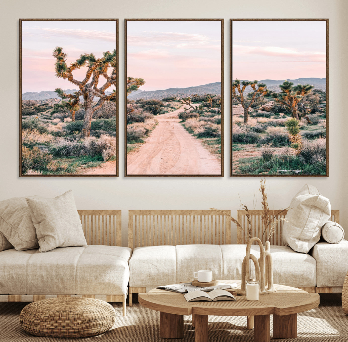 A dusty road winding through Joshua Tree National Park, framed by iconic twisted trees and warm desert tones under a soft pastel sky.