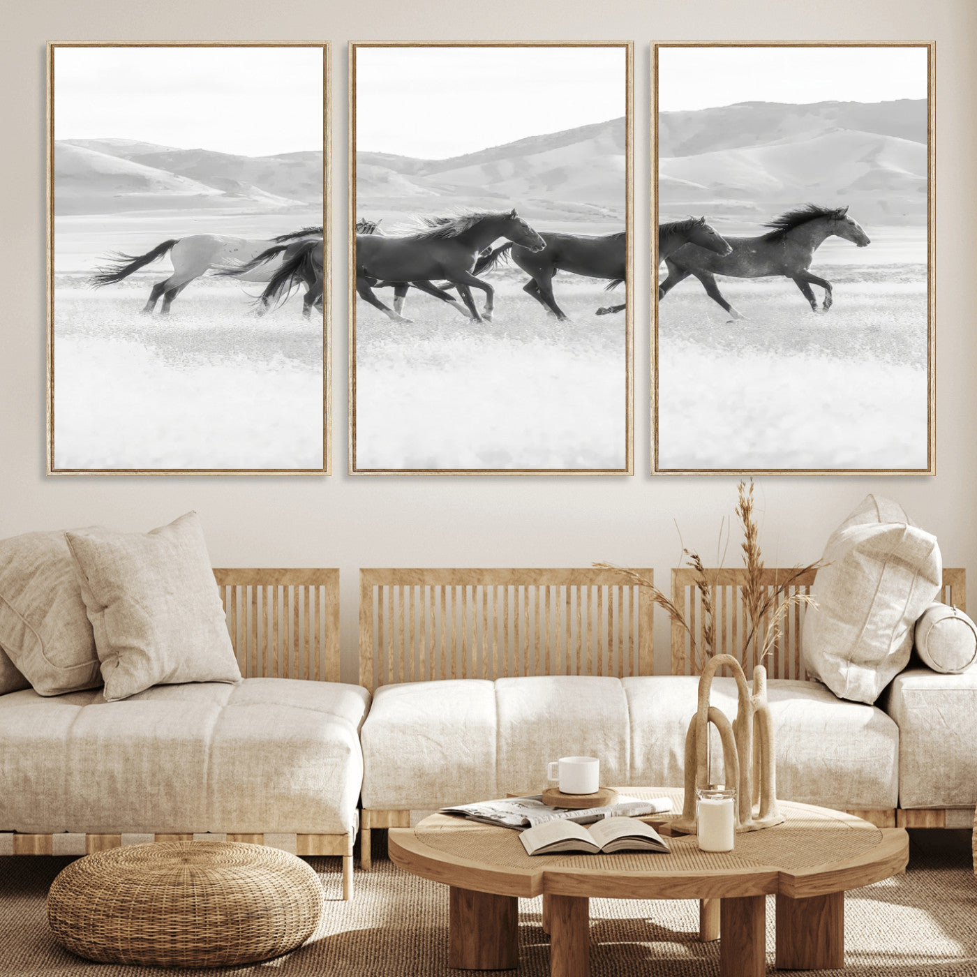 A black and white image of wild horses running freely across an open grassland, capturing the power and beauty of untamed nature in a rustic western setting.