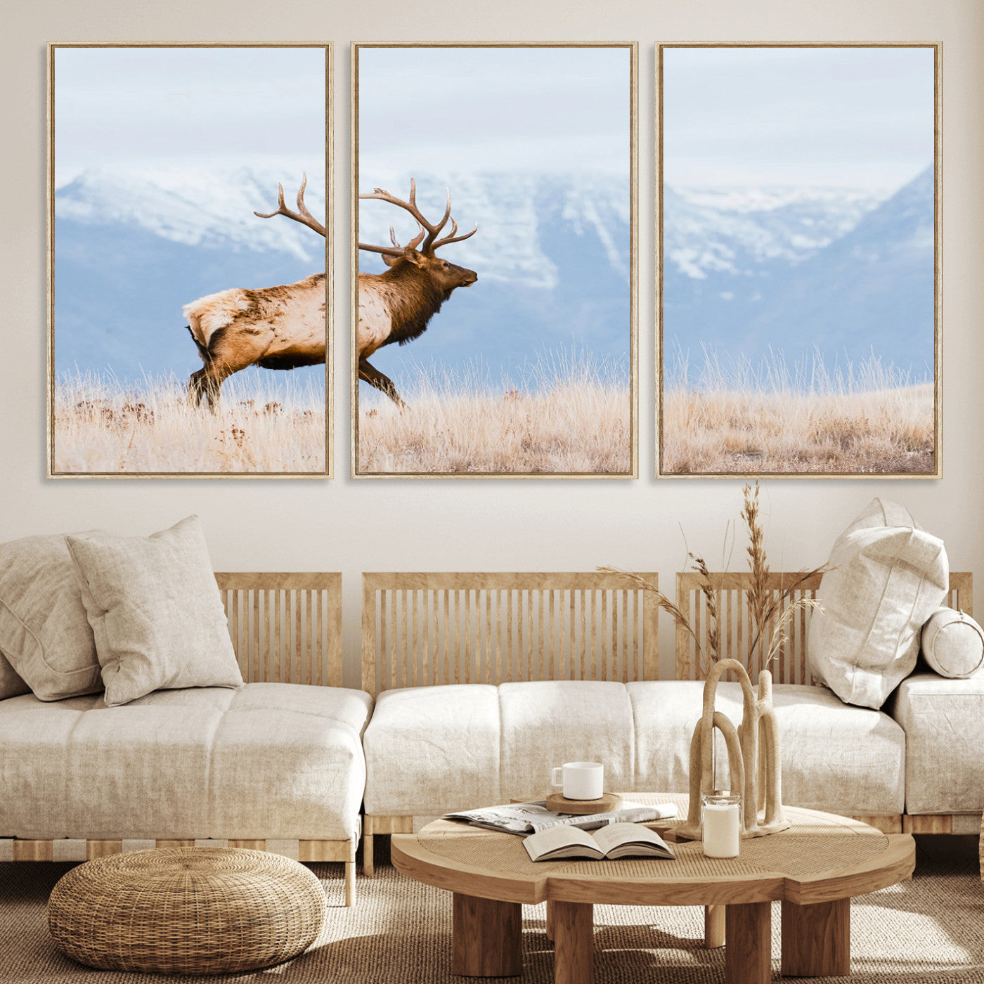 An elk walking on snowy grassland with majestic mountains in the background, ideal for rustic lodge or cabin wall decor.