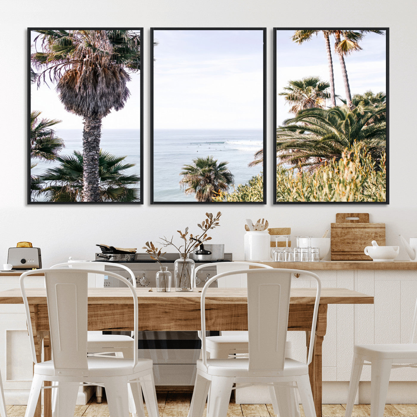 Scenic coastal view with tall palm trees overlooking a calm ocean, soft blue waves, and surfers in the distance, creating a peaceful tropical vibe.