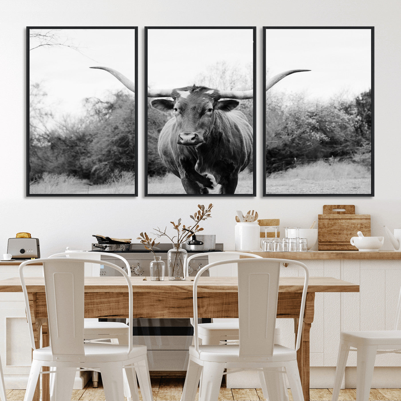 Black and white photo of a longhorn cow in a field, perfect for rustic farmhouse or western-themed interior wall decoration.