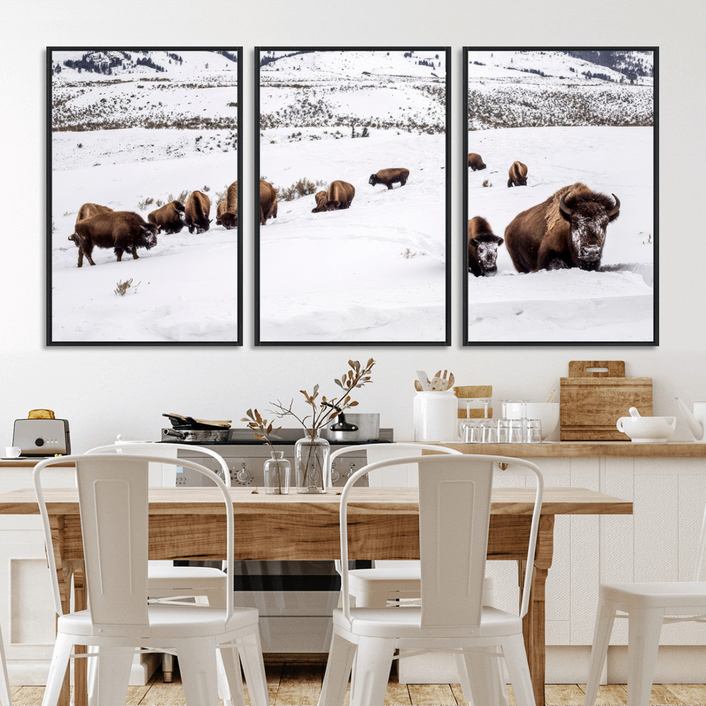 A herd of bison walking through deep snow in a mountain valley, perfect for rustic, cabin or western-themed wall decor.