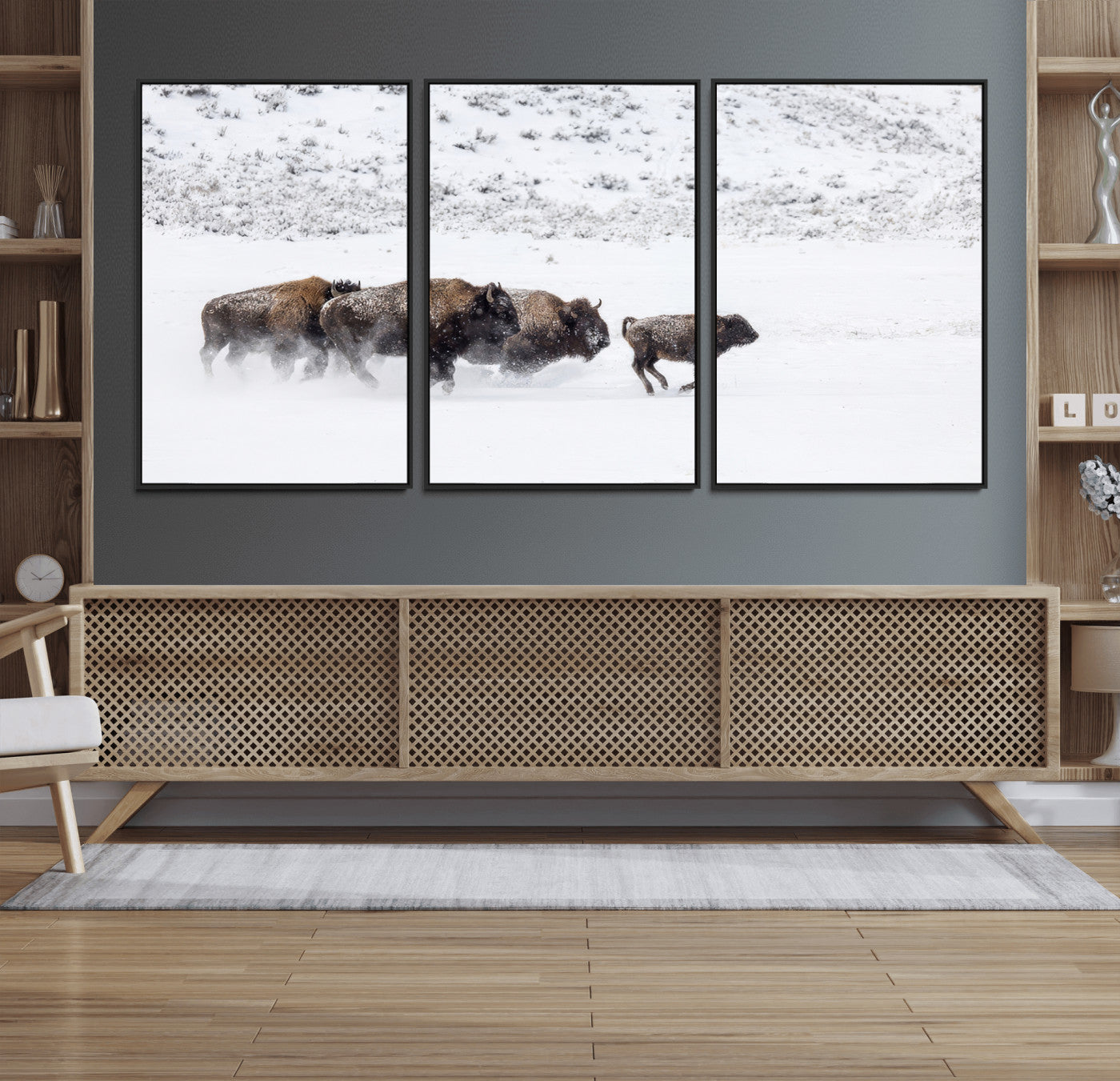 Bison herd running through a snowy open field with mountain backdrop, perfect for rustic or western-themed wall decoration.