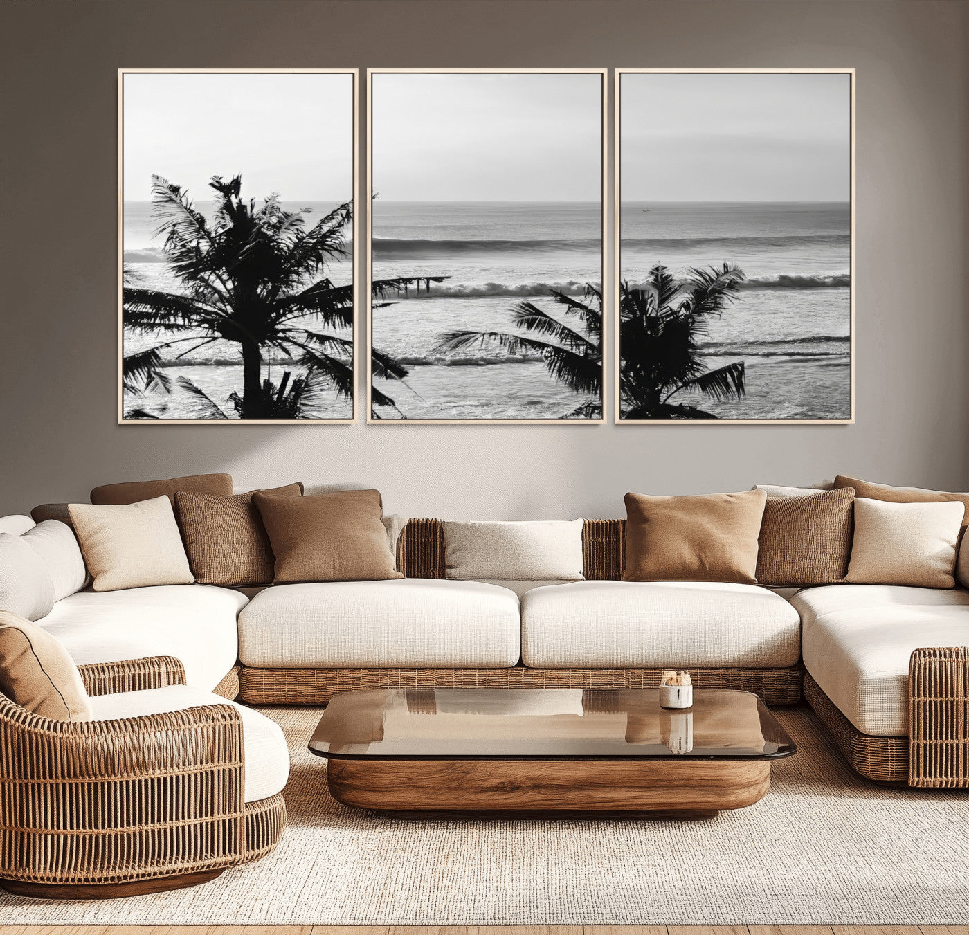 Black and white view of ocean waves crashing on a tropical coastline, framed by silhouetted palm trees under a vast, open sky.