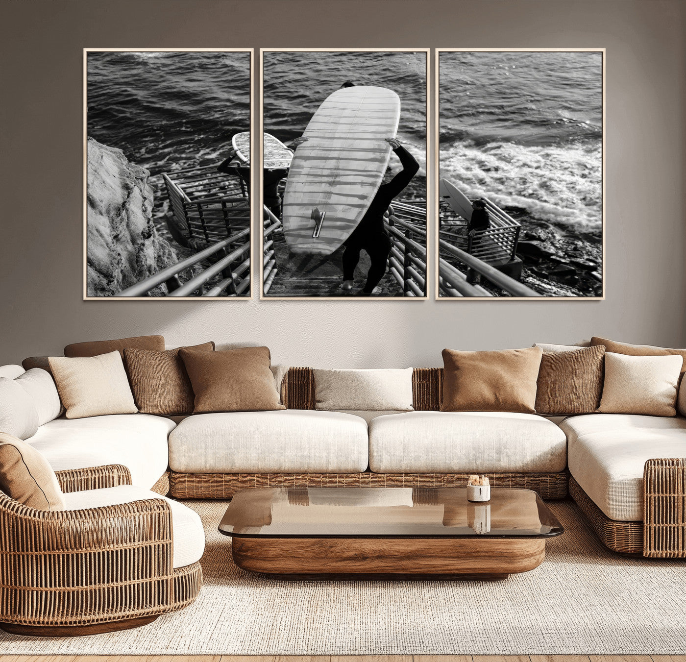 Black and white photo of surfers carrying boards down a rugged cliffside stairway, capturing a bold and adventurous coastal scene.