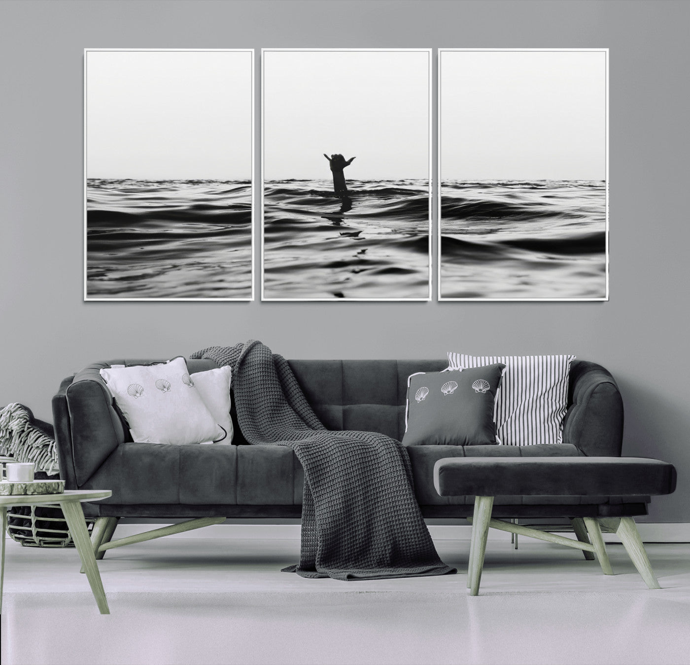 Black and white ocean with a hand making a surfer sign among dark waves, creating a dramatic and minimalist seascape with bold contrast.