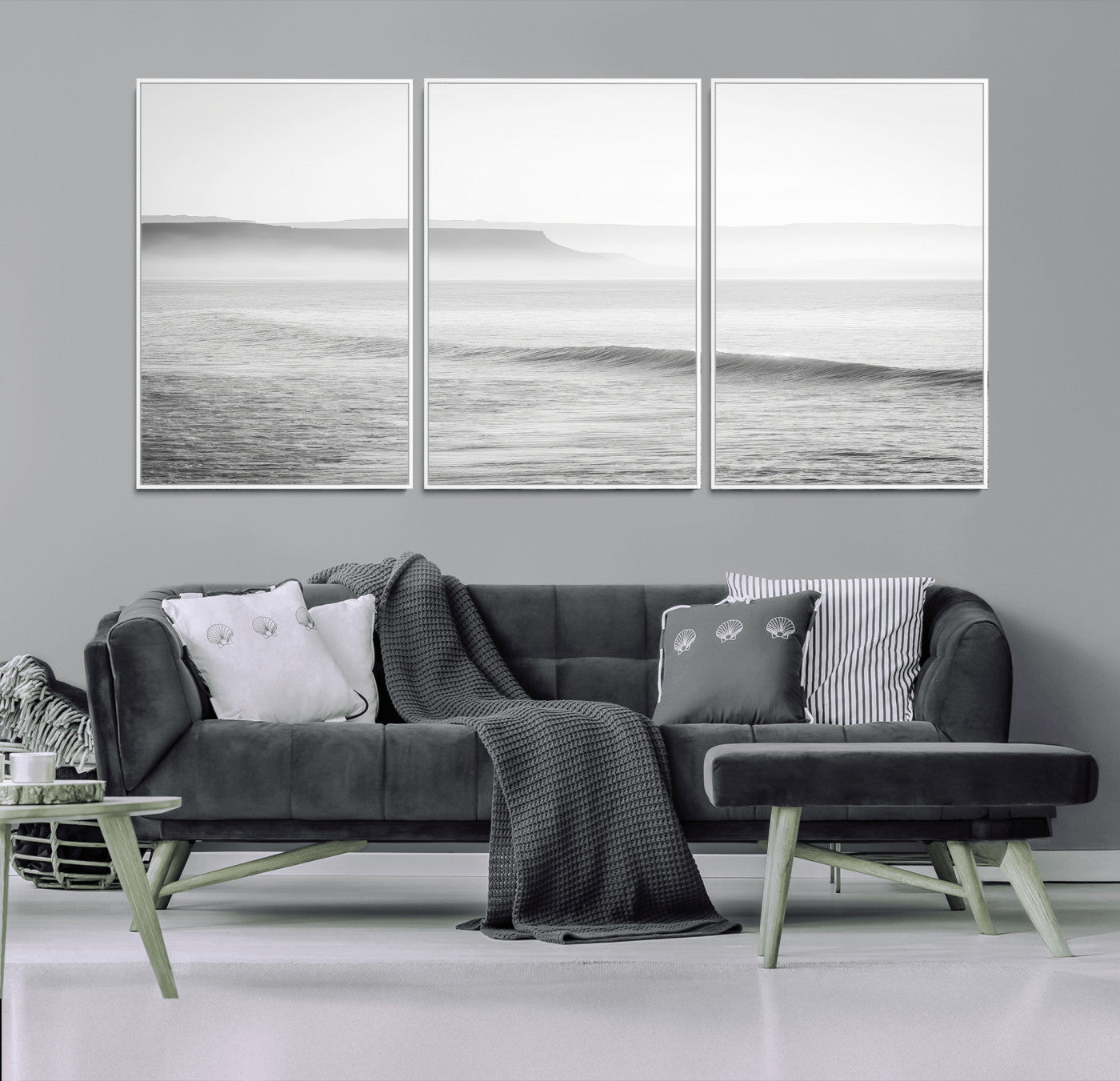 A black and white minimalist seascape featuring soft rolling waves and misty distant cliffs, creating a serene and timeless coastal atmosphere.