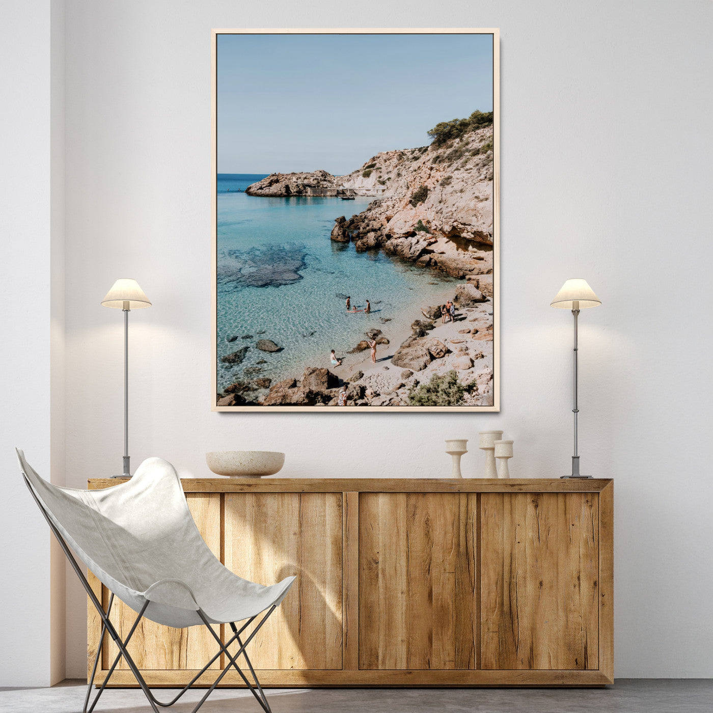 A vibrant coastal photo of a rocky Mediterranean cove with turquoise waters and beachgoers, ideal for boho coastal or summer-inspired interiors.