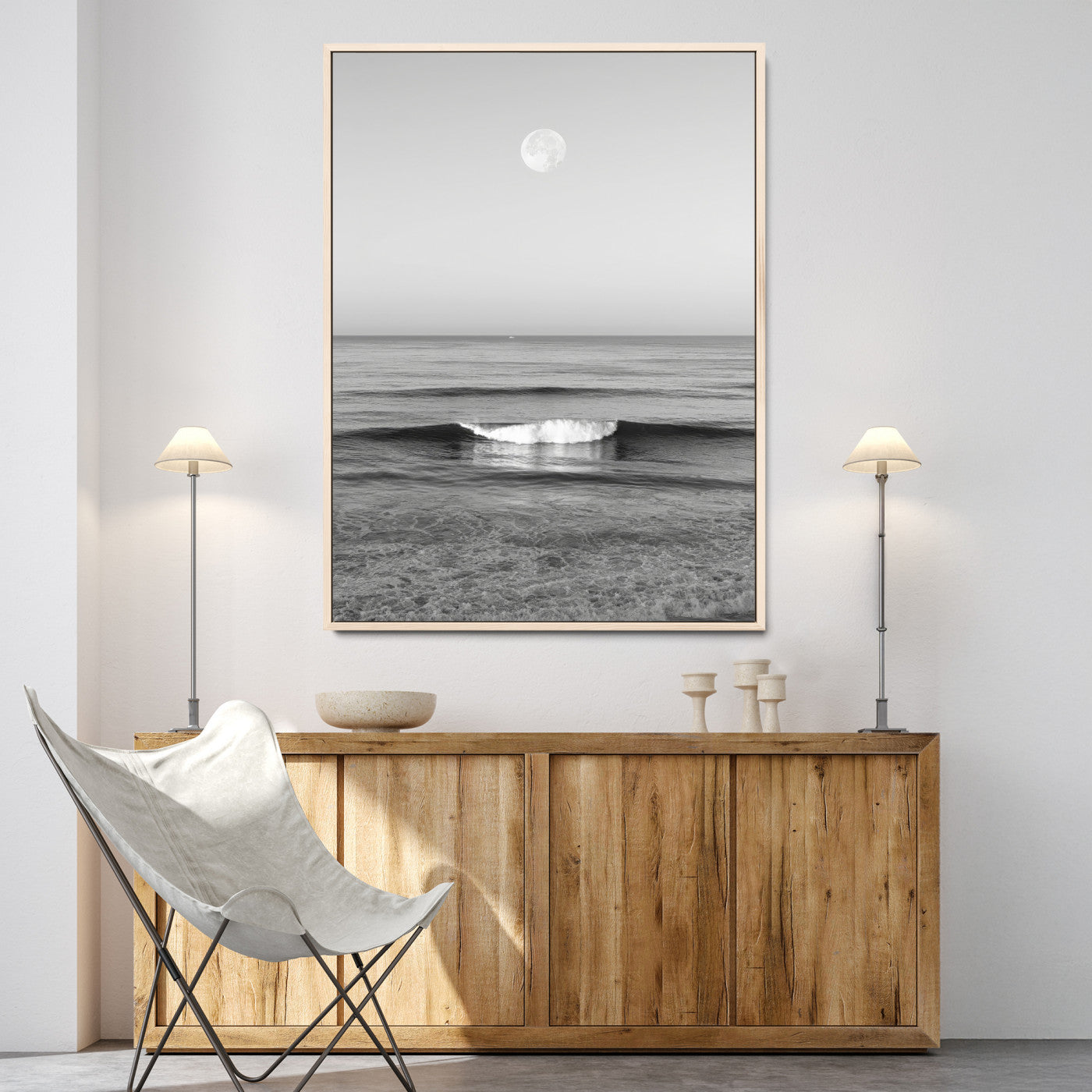 Black and white wall art of a calm ocean wave beneath a full moon, ideal for minimalist or monochrome coastal decor.