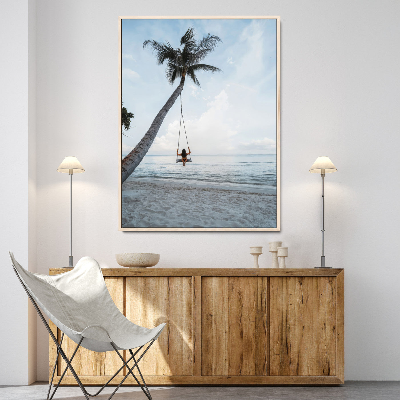Wall art of a girl on a swing hanging from a palm tree over calm ocean waters, perfect for tropical or minimalist coastal decor.