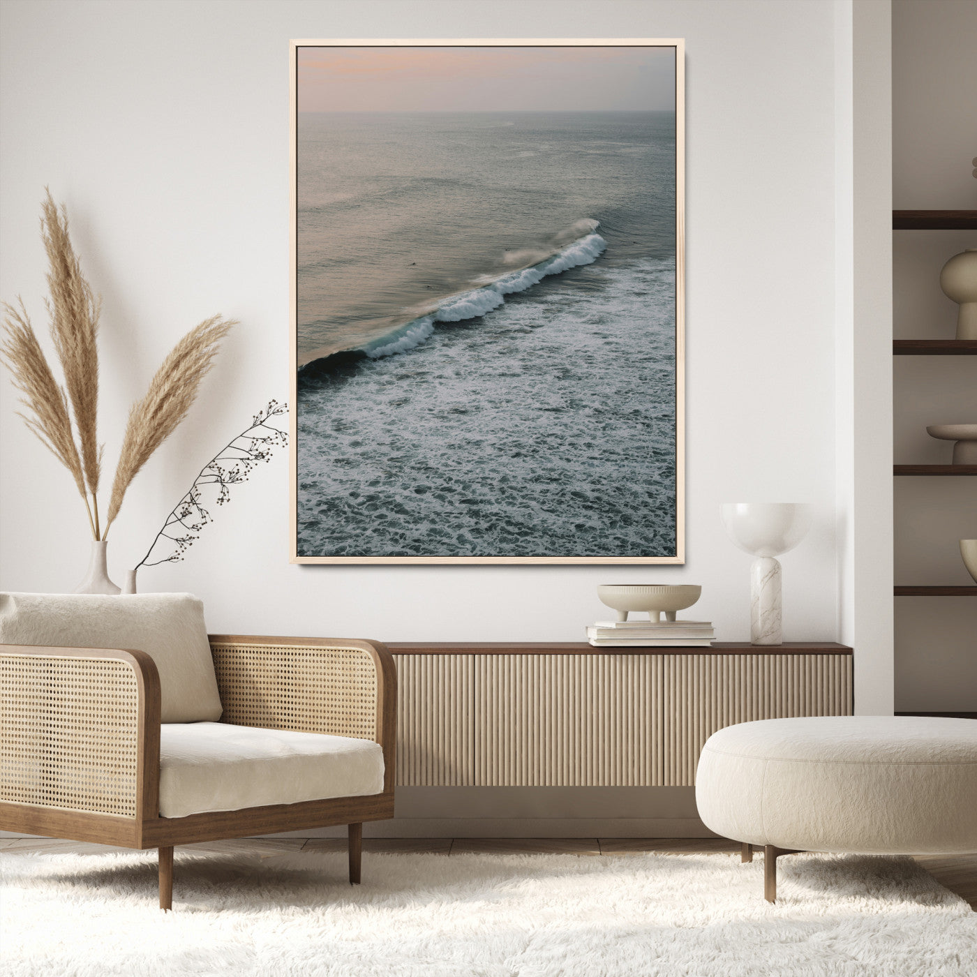 Aerial view of ocean waves rolling towards the shore under a soft sunset sky, creating a peaceful and minimalist coastal scene.