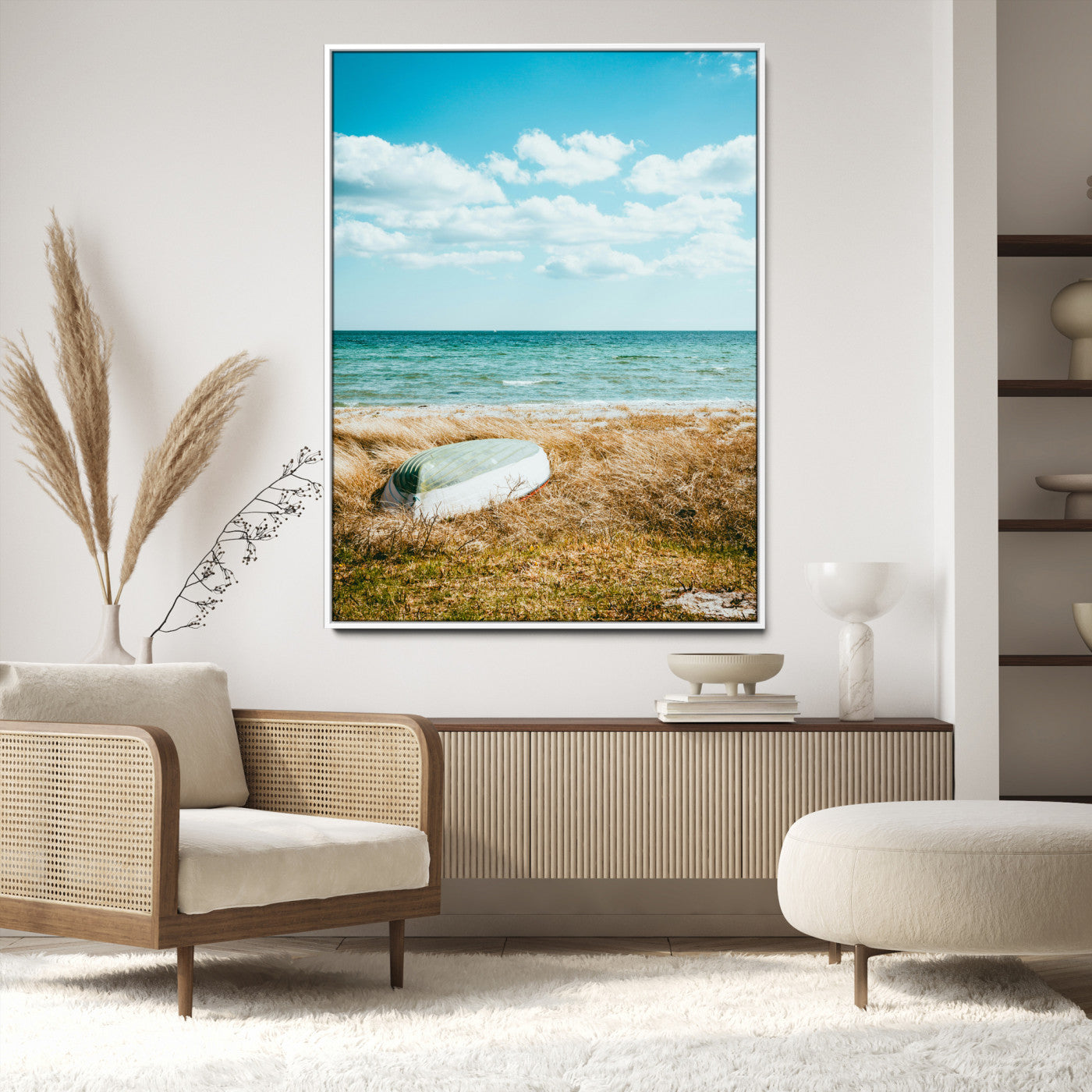 A small boat resting on a grassy shore with ocean waves and a bright blue sky, creating a peaceful coastal atmosphere.