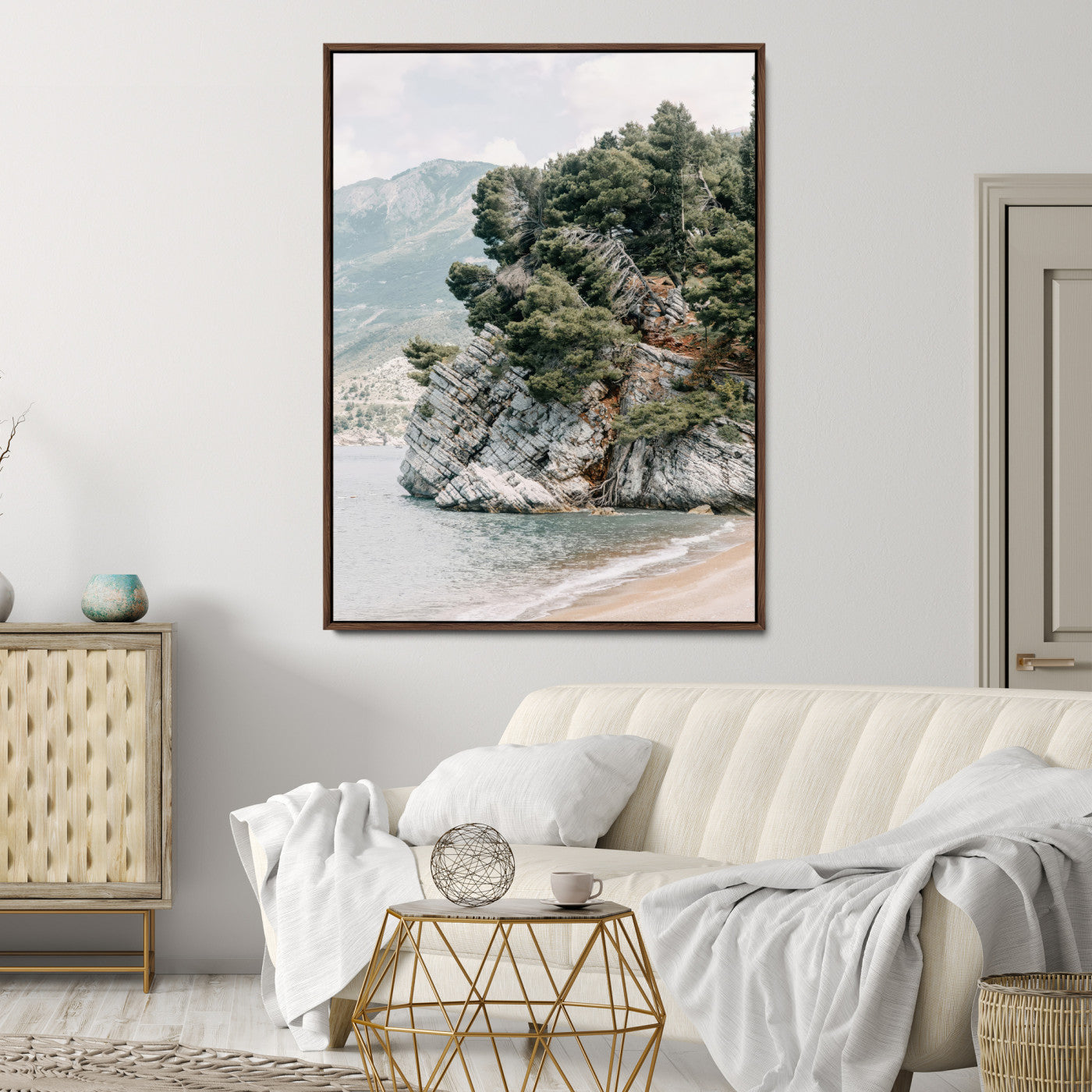 Framed photo of a rocky coastal cliff with dense greenery and calm shoreline, ideal for rustic coastal or earthy-toned home decor.