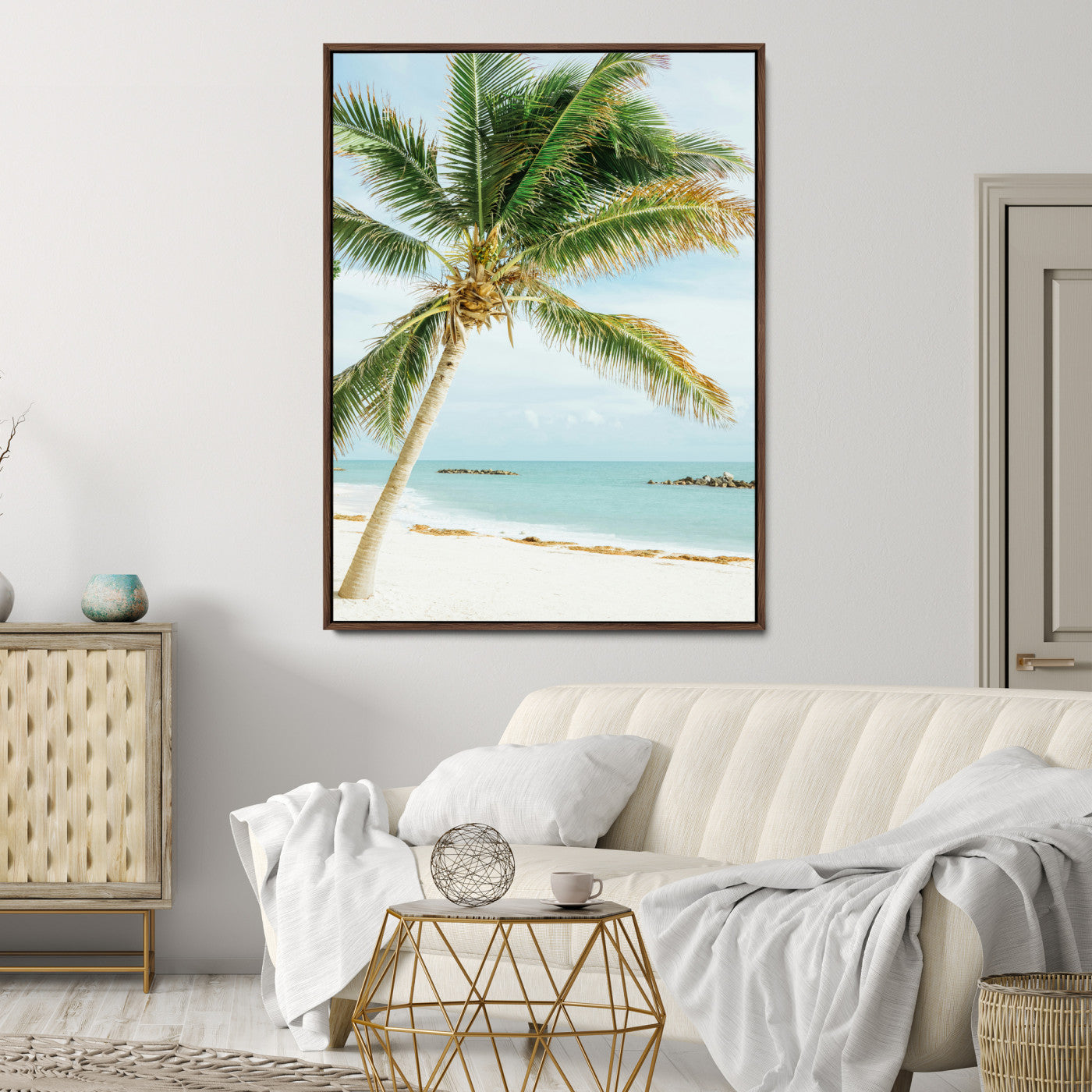 A tall palm tree leaning over a white sandy beach with turquoise ocean waves, creating a peaceful and tropical coastal scene.