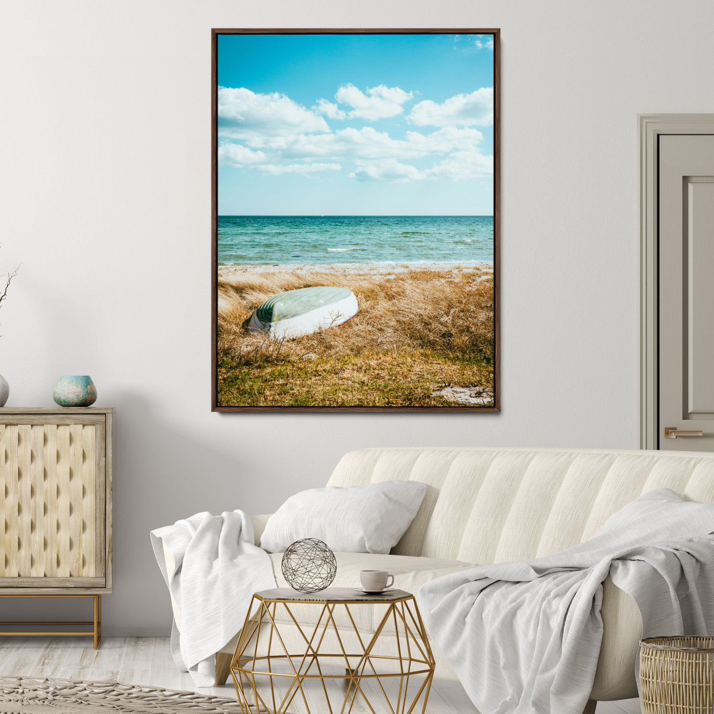 A small boat resting on a grassy shore with ocean waves and a bright blue sky, creating a peaceful coastal atmosphere.