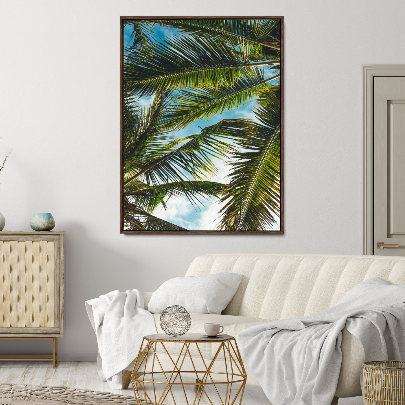 Looking up at lush green palm leaves against a bright blue sky, creating a tropical and relaxing coastal aesthetic.