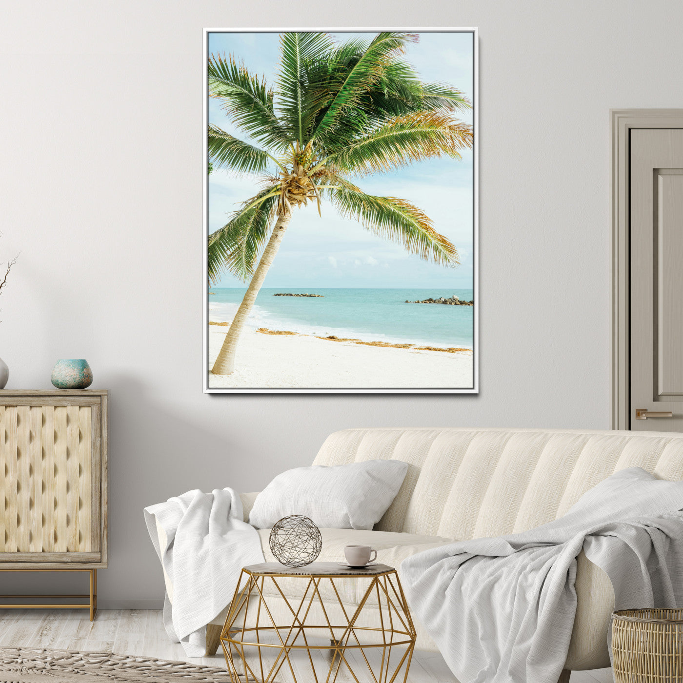 A tall palm tree leaning over a white sandy beach with turquoise ocean waves, creating a peaceful and tropical coastal scene.