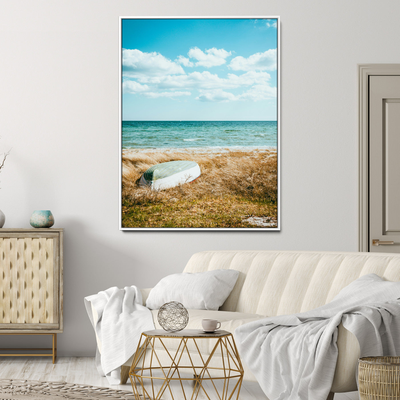 A small boat resting on a grassy shore with ocean waves and a bright blue sky, creating a peaceful coastal atmosphere.