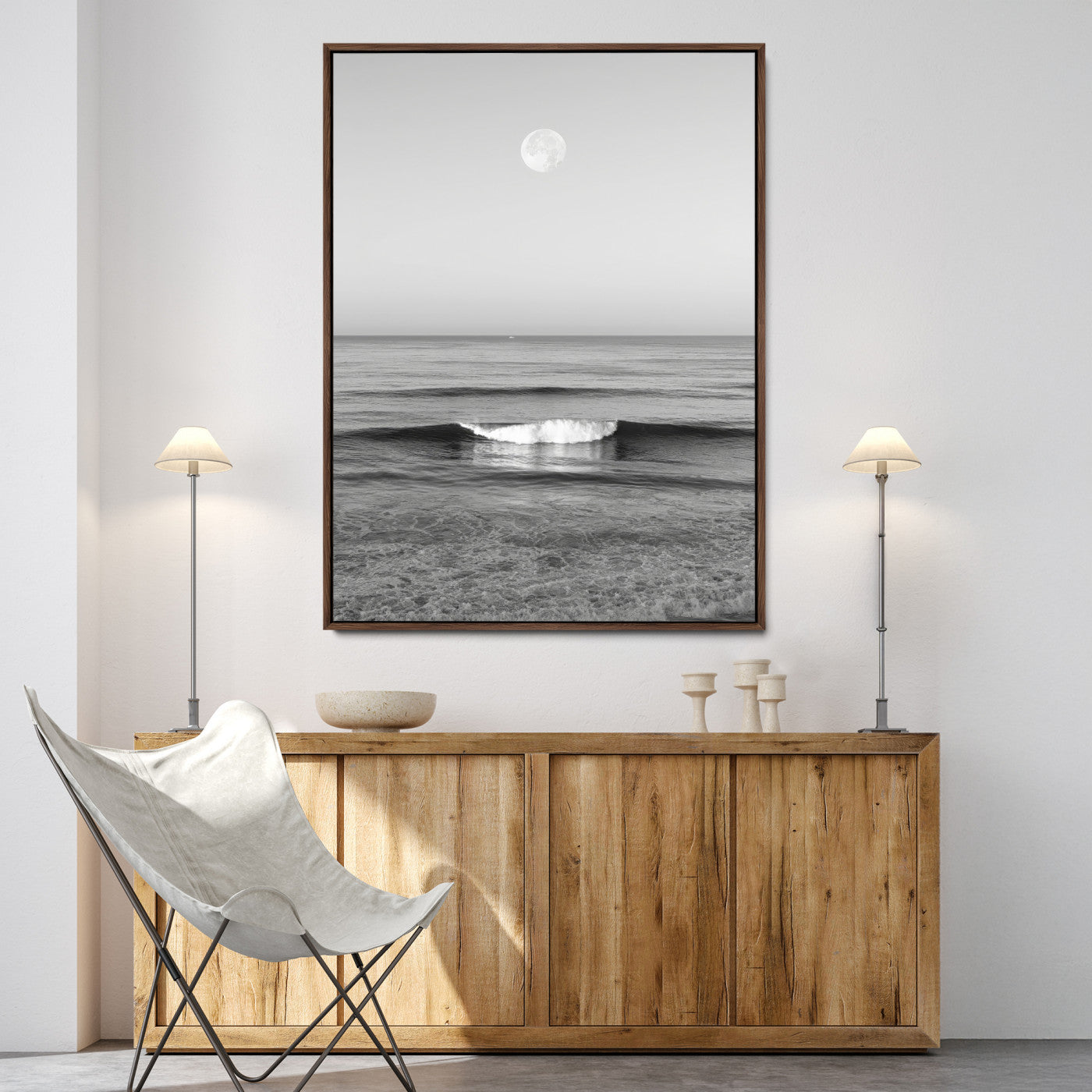 Black and white wall art of a calm ocean wave beneath a full moon, ideal for minimalist or monochrome coastal decor.