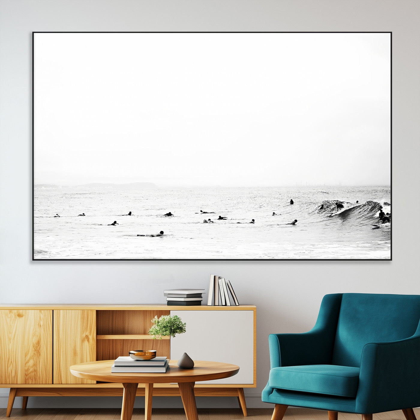 A group of surfers floating in the ocean, waiting for waves under a vast, moody sky, captured in black and white.