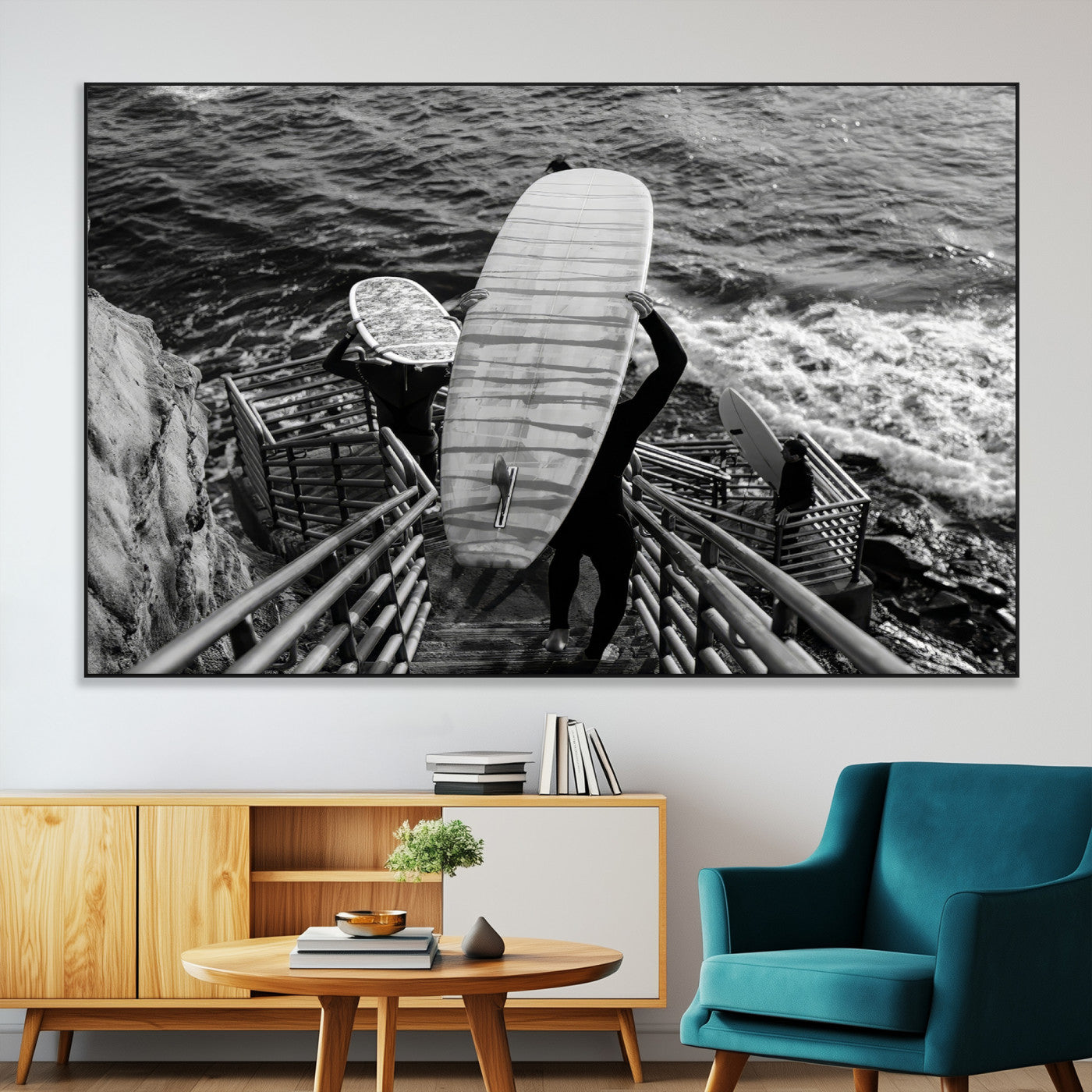 Black and white photo of surfers carrying boards down a rugged cliffside stairway, capturing a bold and adventurous coastal scene.