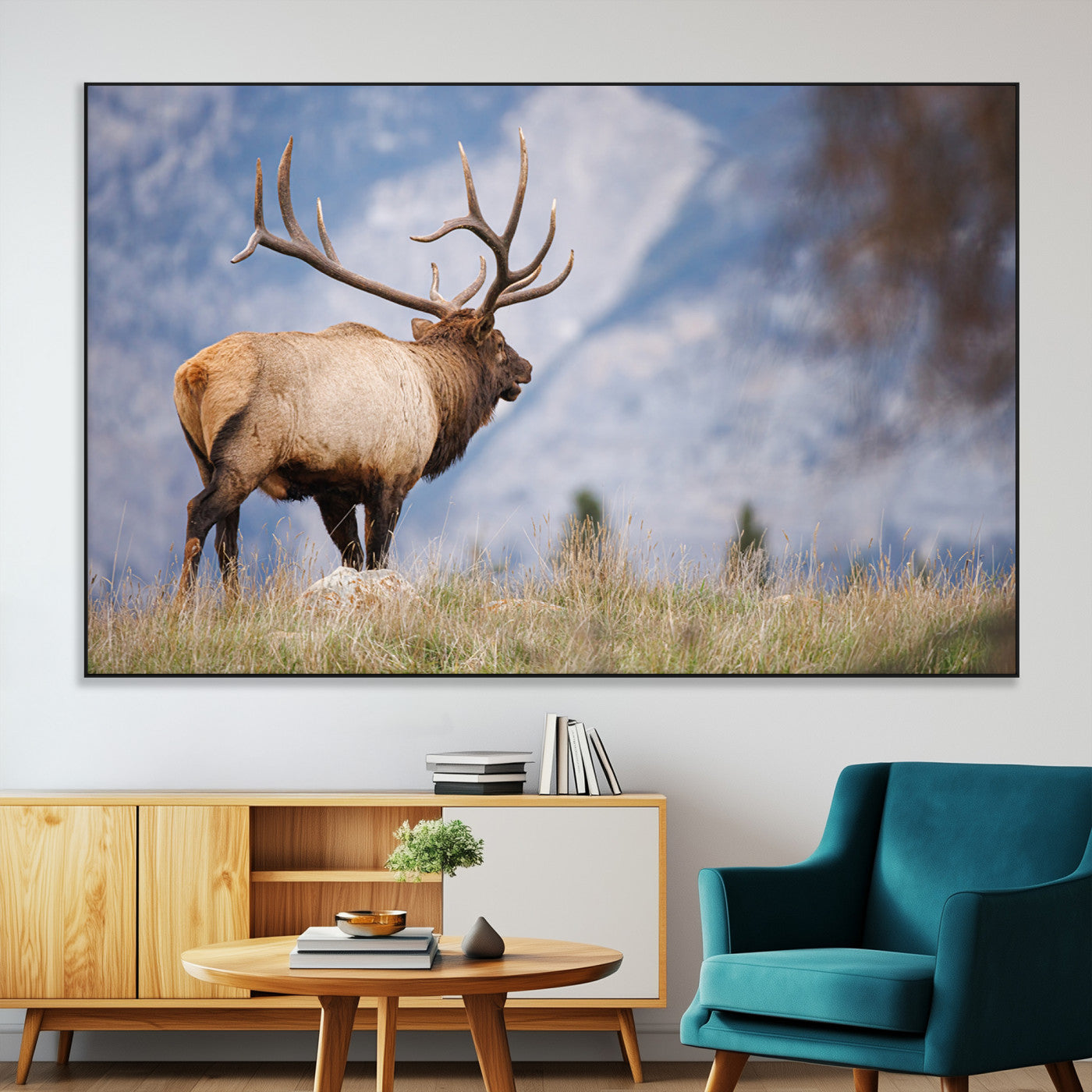 Elk with antlers standing on grass with mountain background, ideal for rustic, cabin, or lodge-inspired wall decor.