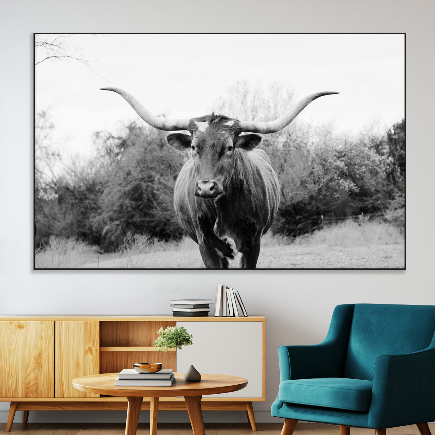 Black and white photo of a longhorn cow in a field, perfect for rustic farmhouse or western-themed interior wall decoration.