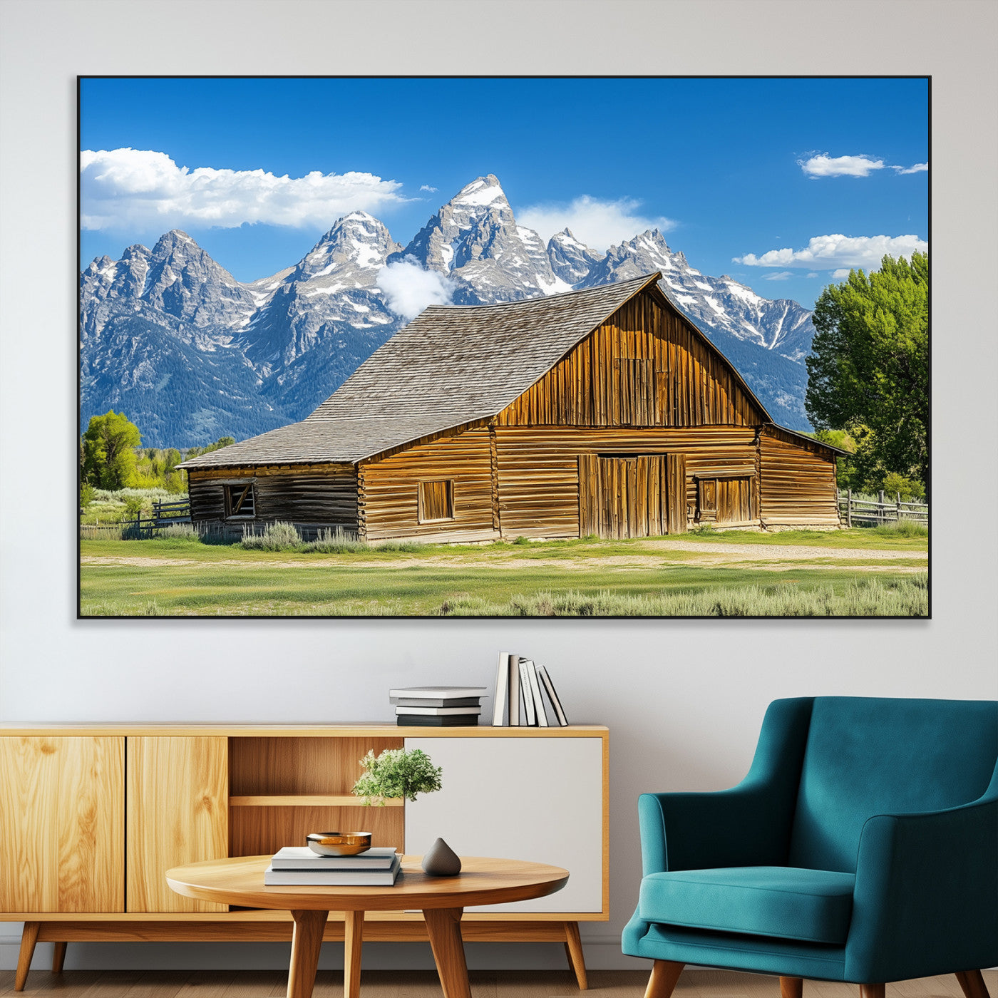 A rustic wooden barn sits in front of towering mountain peaks under a clear blue sky, perfect for farmhouse or cabin style interiors.