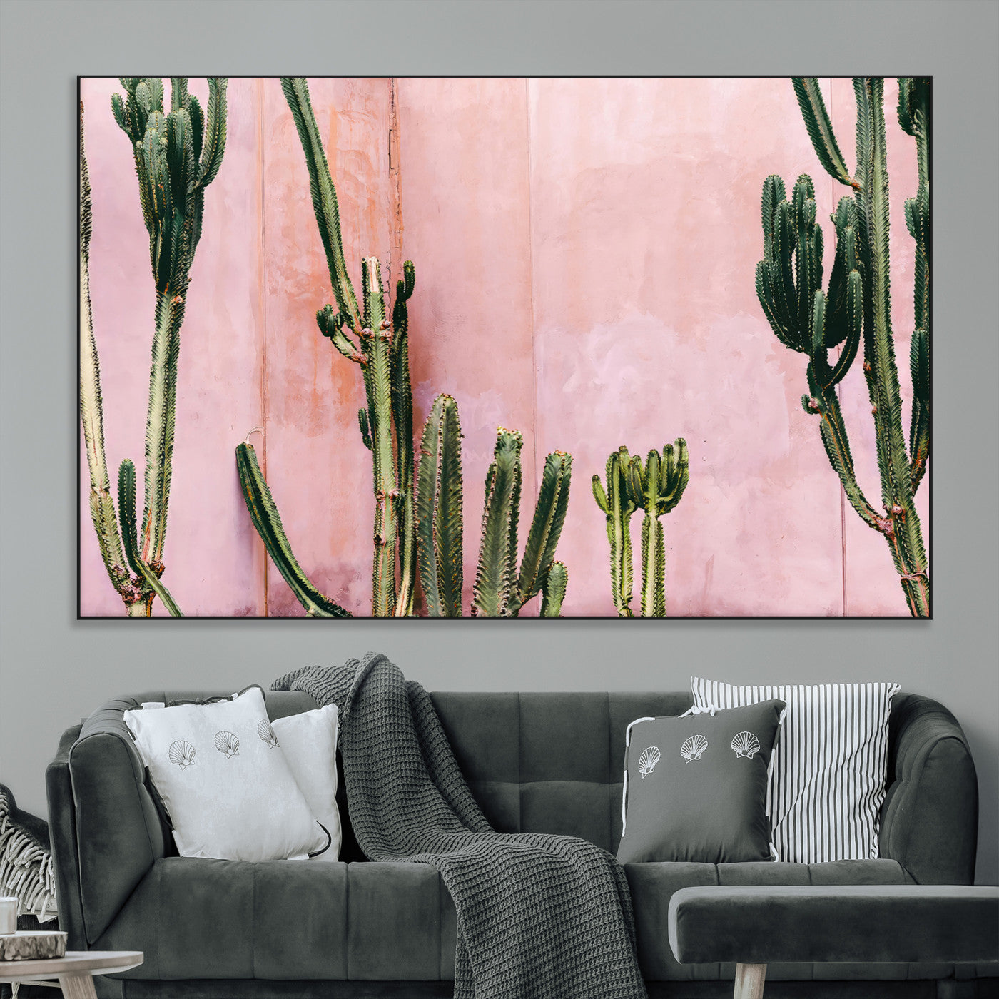 Framed canvas of tall green cacti against a soft pink wall, ideal for modern desert or colorful southwest-inspired home decor.