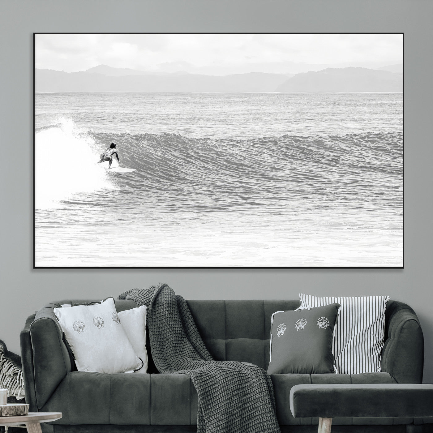 Monochrome photo of a surfer riding a wave with distant mountains, ideal for coastal motion or black and white surf-themed wall decor.