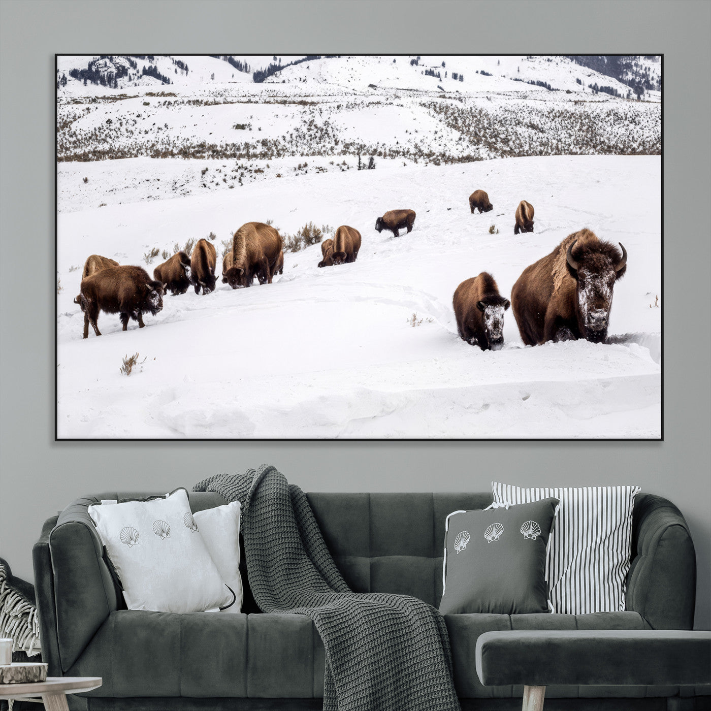 A herd of bison walking through deep snow in a mountain valley, perfect for rustic, cabin or western-themed wall decor.
