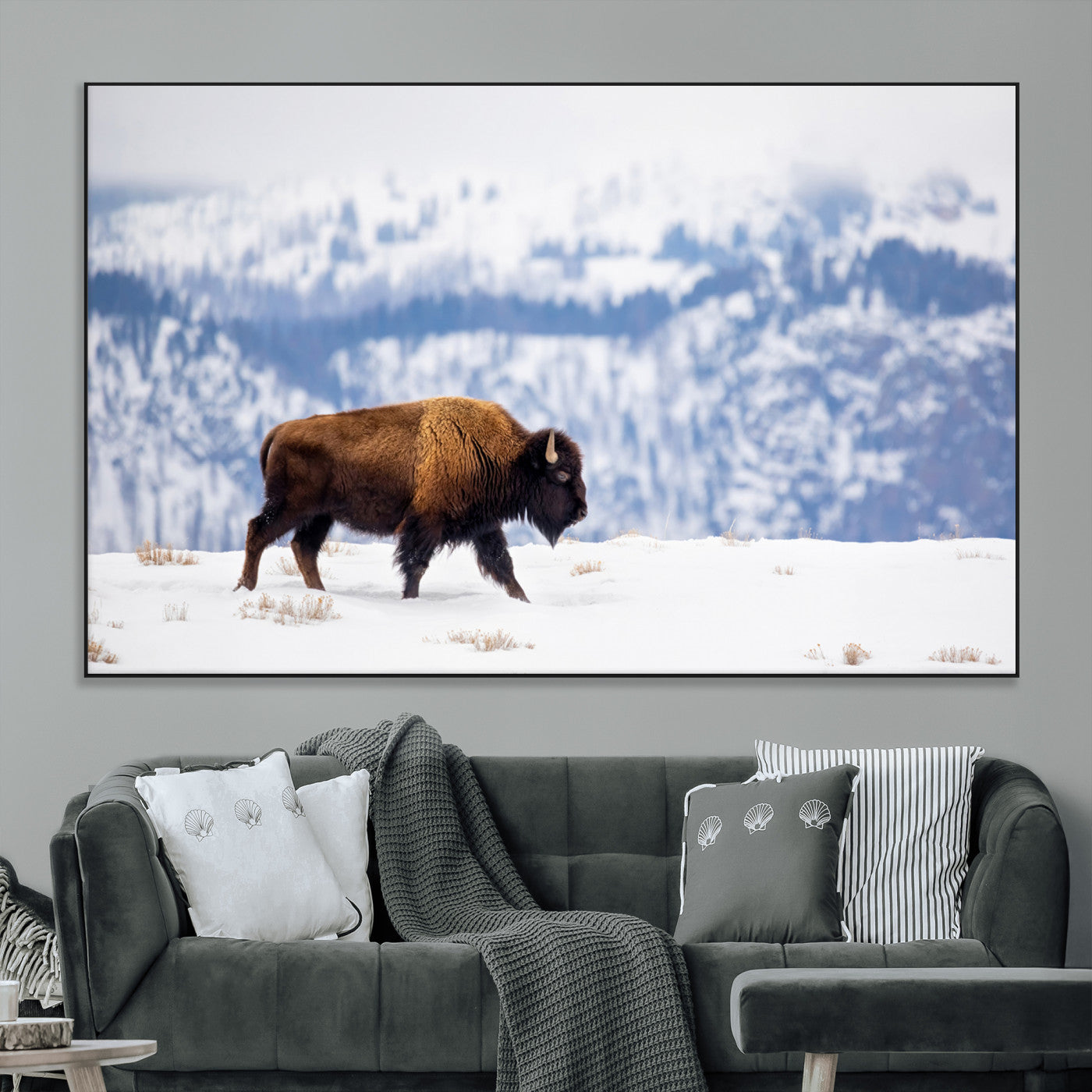 A lone bison walks across snowy ground with blue-toned mountain range behind, ideal for rustic or western farmhouse interiors.