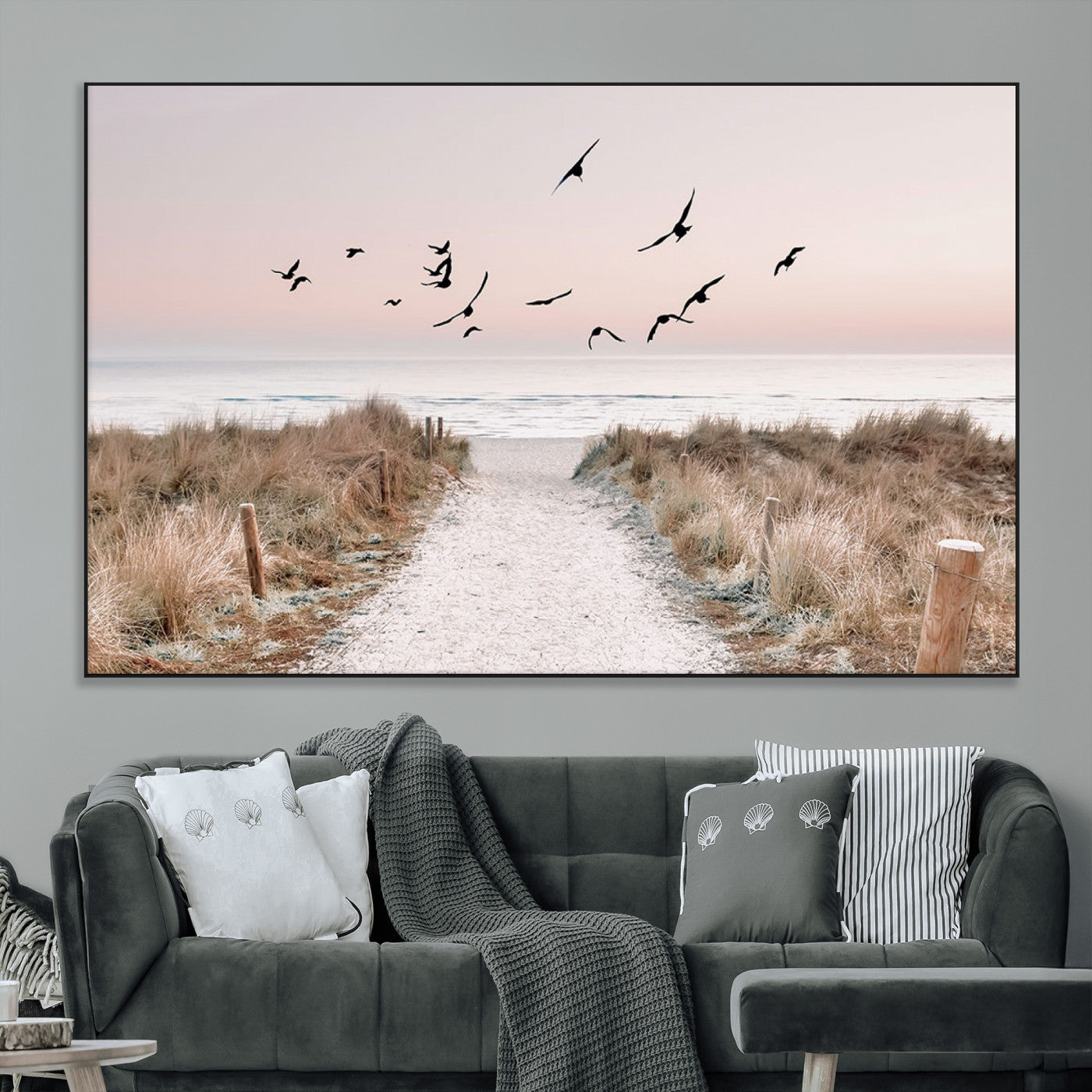 A peaceful coastal pathway leading to the ocean, with birds flying across a soft pastel sky, creating a calm and scenic beach atmosphere.