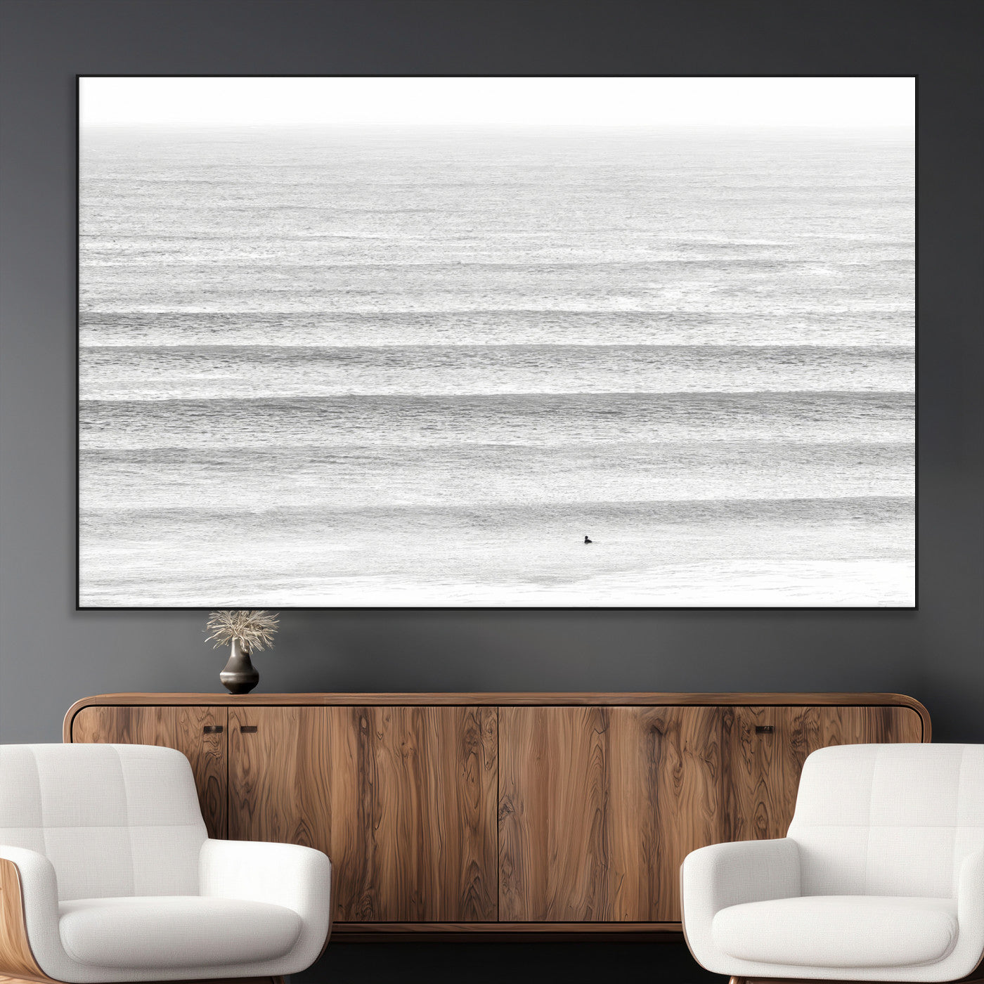Monochrome photo of a lone surfer in calm layered waves, perfect for minimalist coastal or moody ocean-inspired wall decoration.