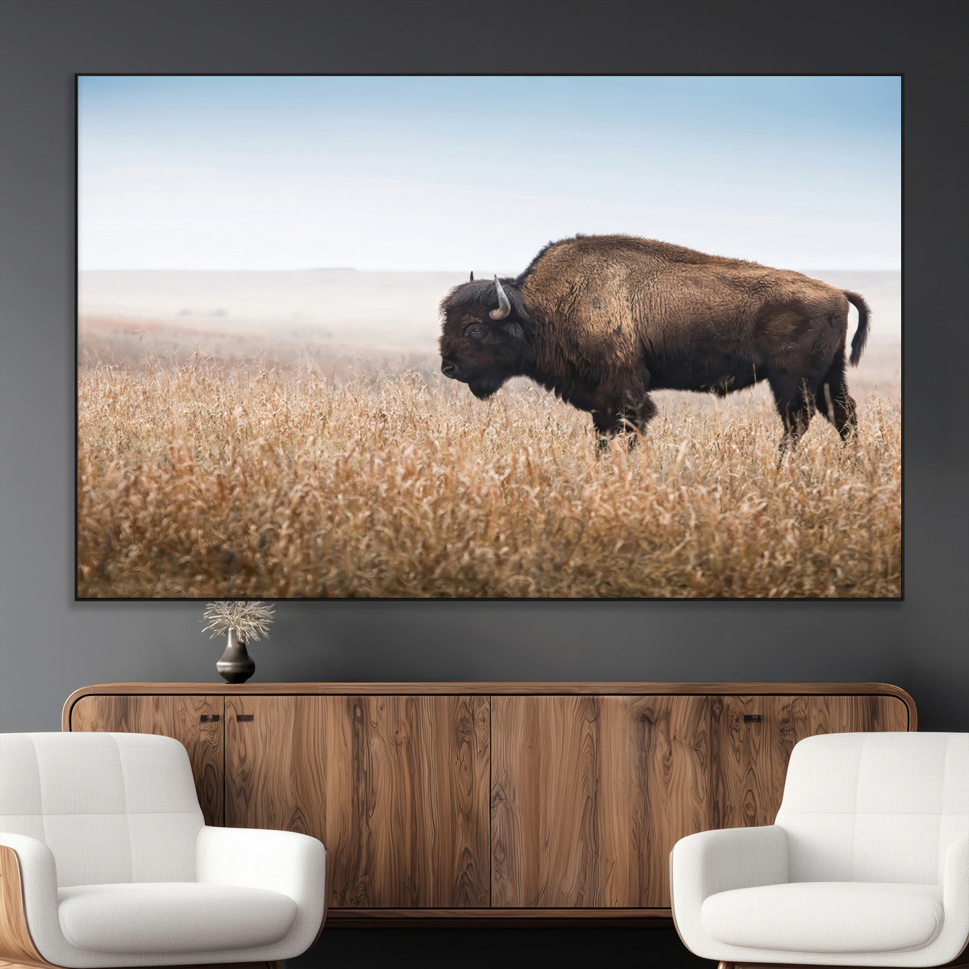 A majestic bison standing in an open prairie field, its strong form blending into the golden grass under a vast blue sky, evoking the wild spirit of the American plains.