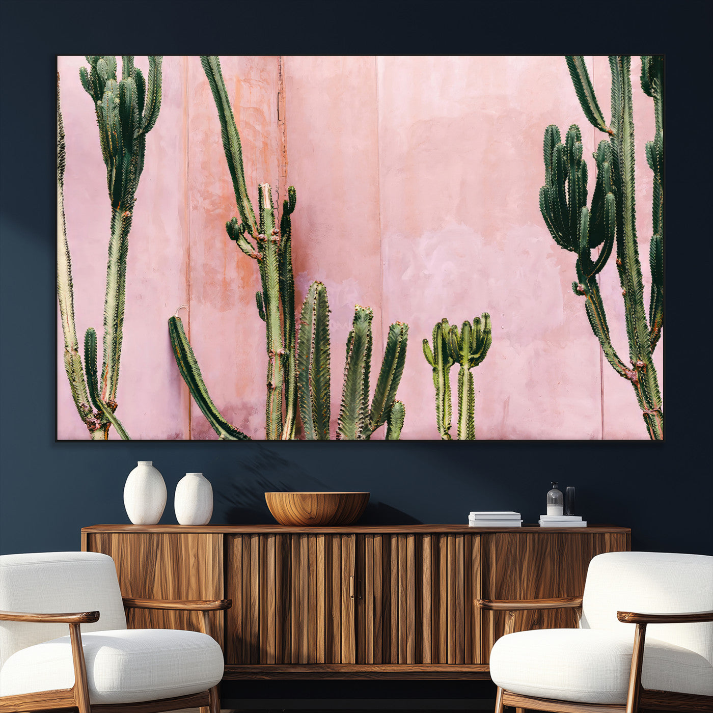 Framed canvas of tall green cacti against a soft pink wall, ideal for modern desert or colorful southwest-inspired home decor.