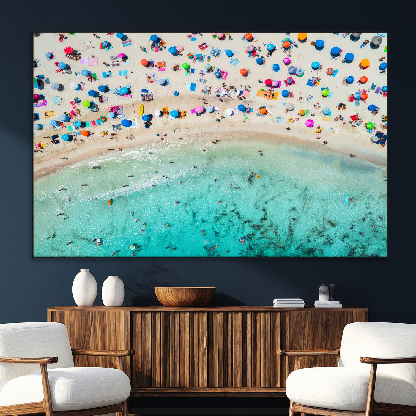 Aerial view of a vibrant beach filled with colorful umbrellas and people enjoying the turquoise ocean, capturing a lively summer vacation scene.