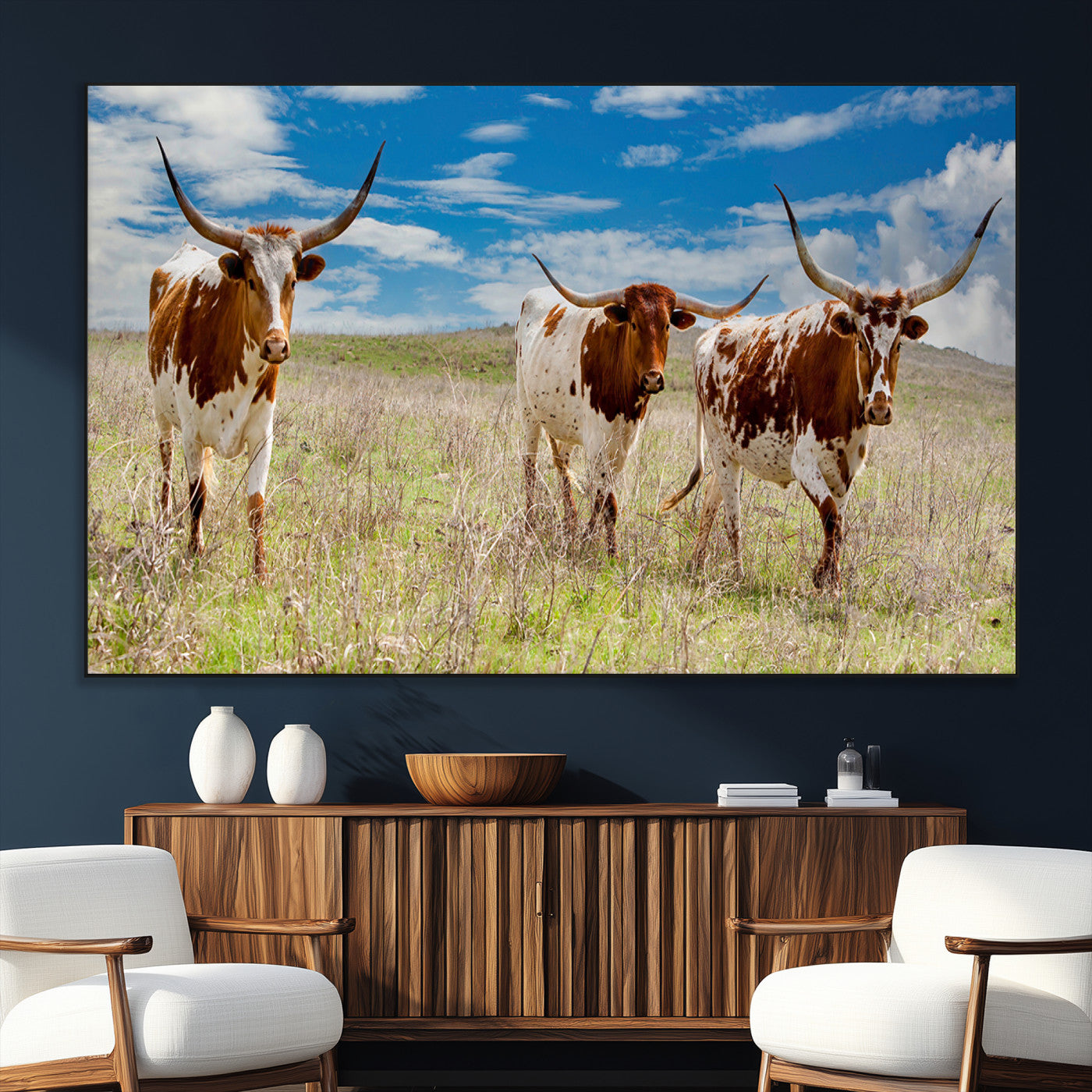 Three Texas longhorn cattle standing in dry grass under a bright blue sky, ideal for farmhouse or western rustic home decor.