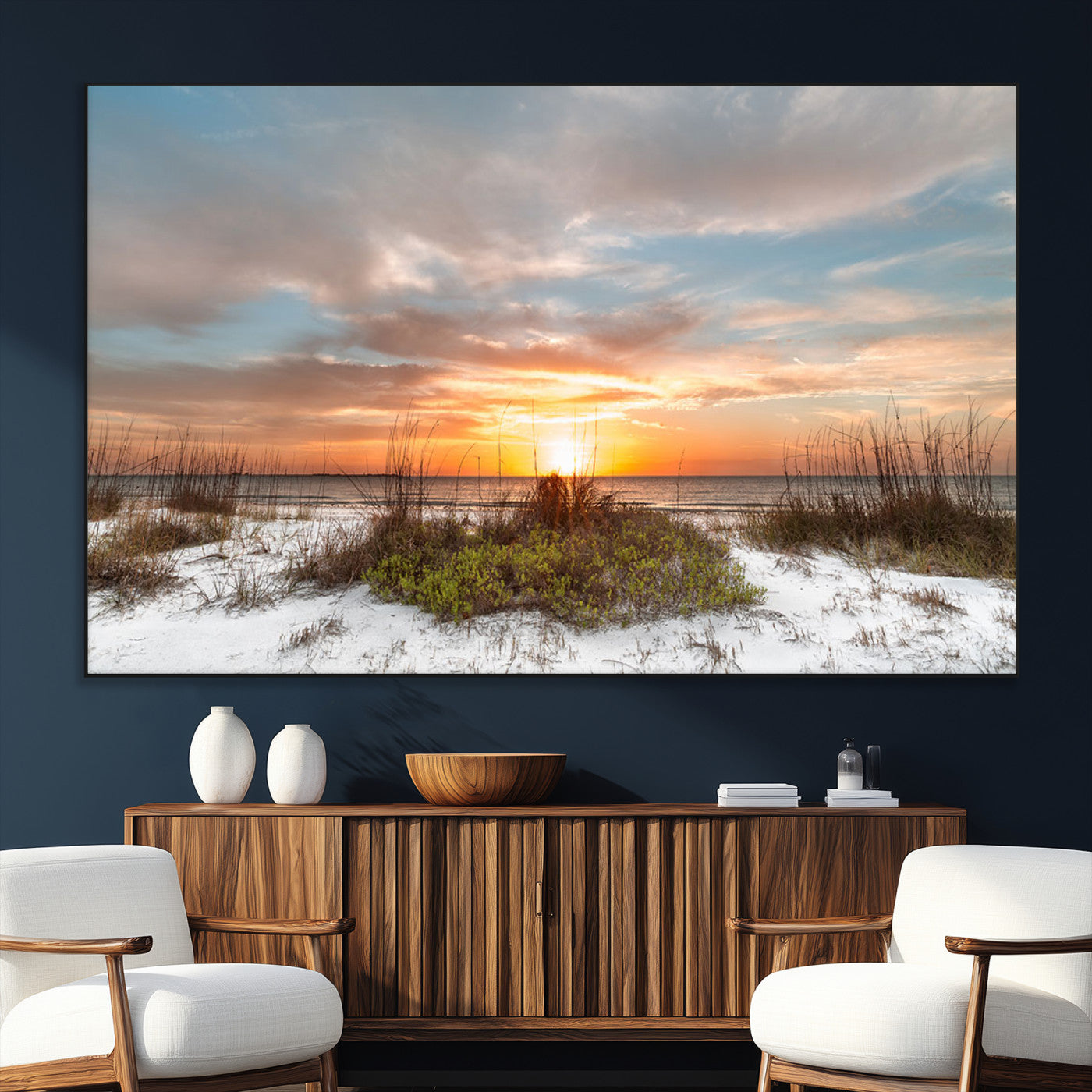 A tranquil beach scene featuring golden sunset hues over the water, with grasses in the foreground and a peaceful, serene atmosphere.
