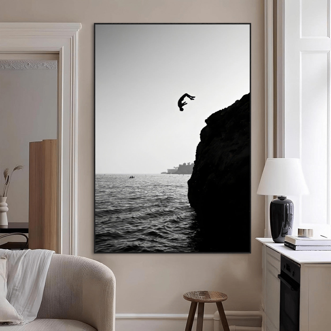 Silhouette of a person mid-air during a cliff jump over the ocean, captured in black and white for minimalist adventure decor.