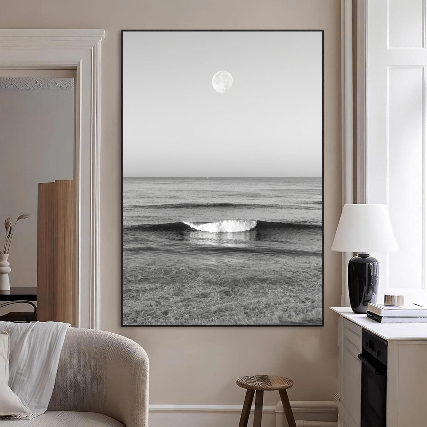 Black and white wall art of a calm ocean wave beneath a full moon, ideal for minimalist or monochrome coastal decor.