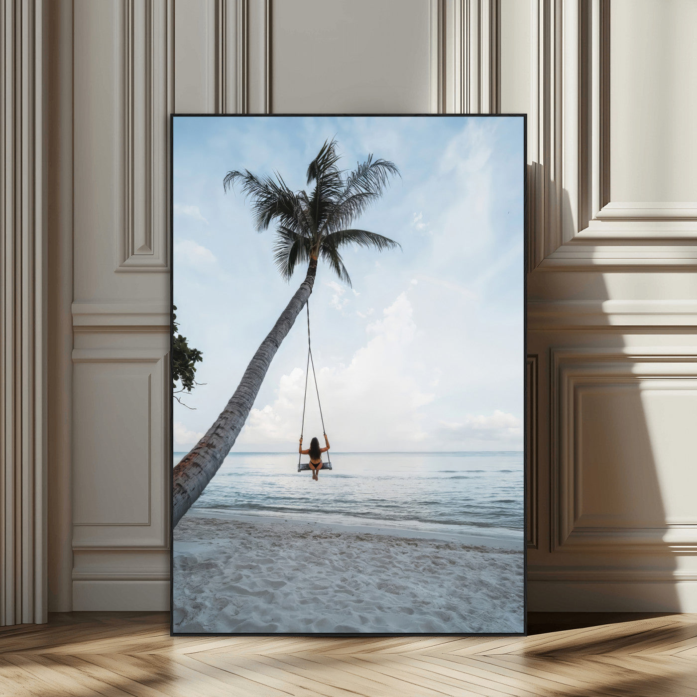 Wall art of a girl on a swing hanging from a palm tree over calm ocean waters, perfect for tropical or minimalist coastal decor.