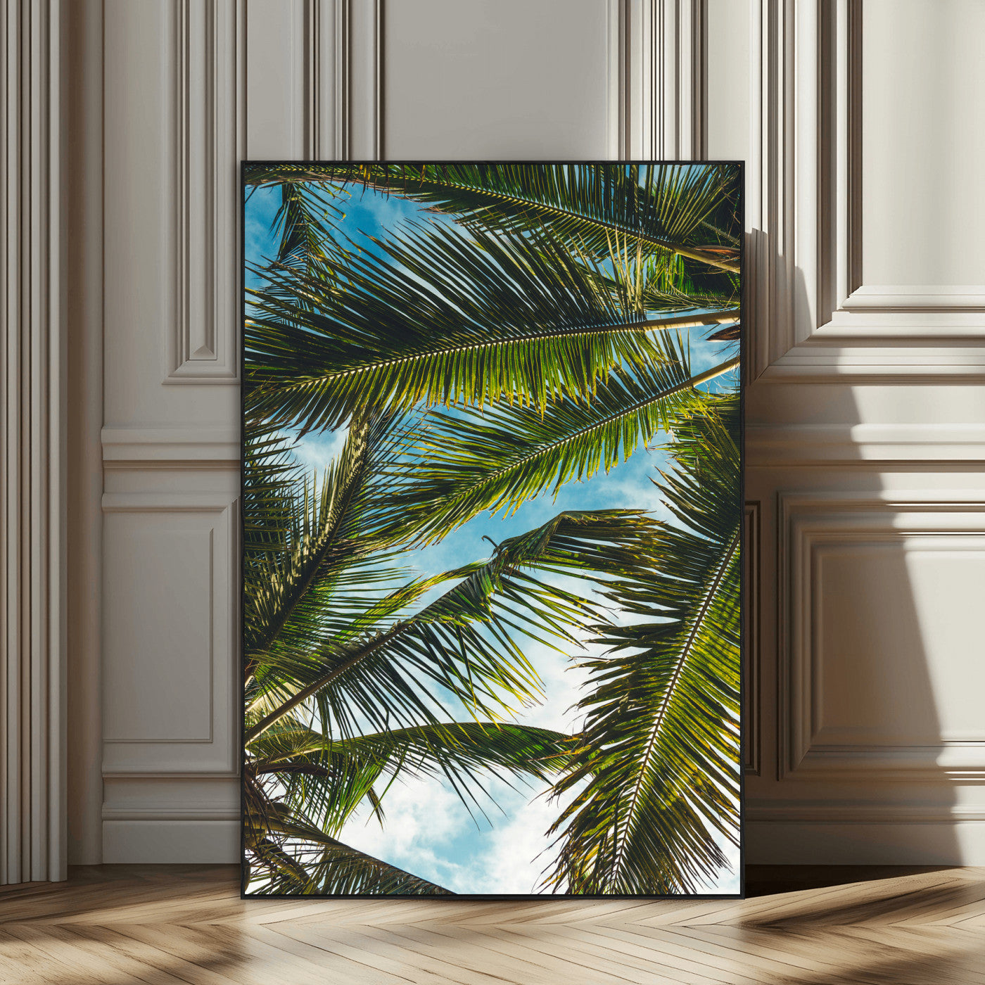 Looking up at lush green palm leaves against a bright blue sky, creating a tropical and relaxing coastal aesthetic.