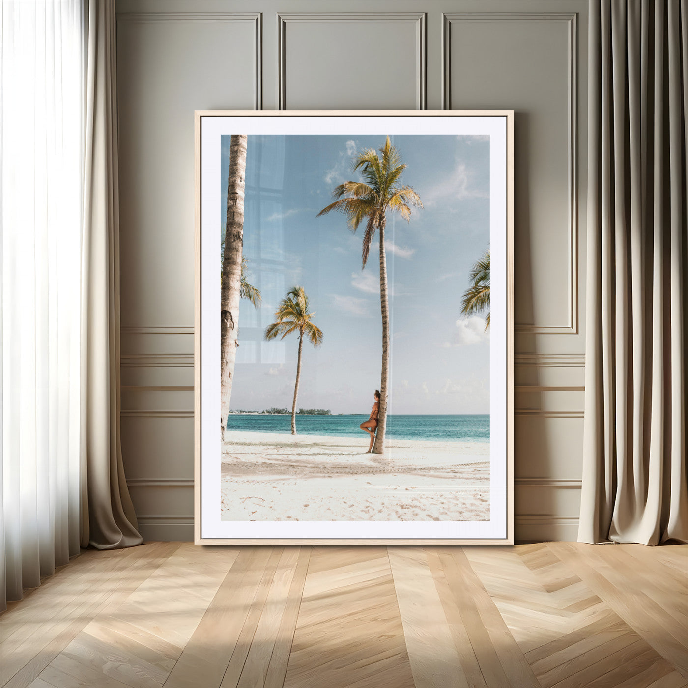 Person leaning on a palm tree at a tropical beach with white sand and turquoise water, perfect for coastal or beach-themed home decor.