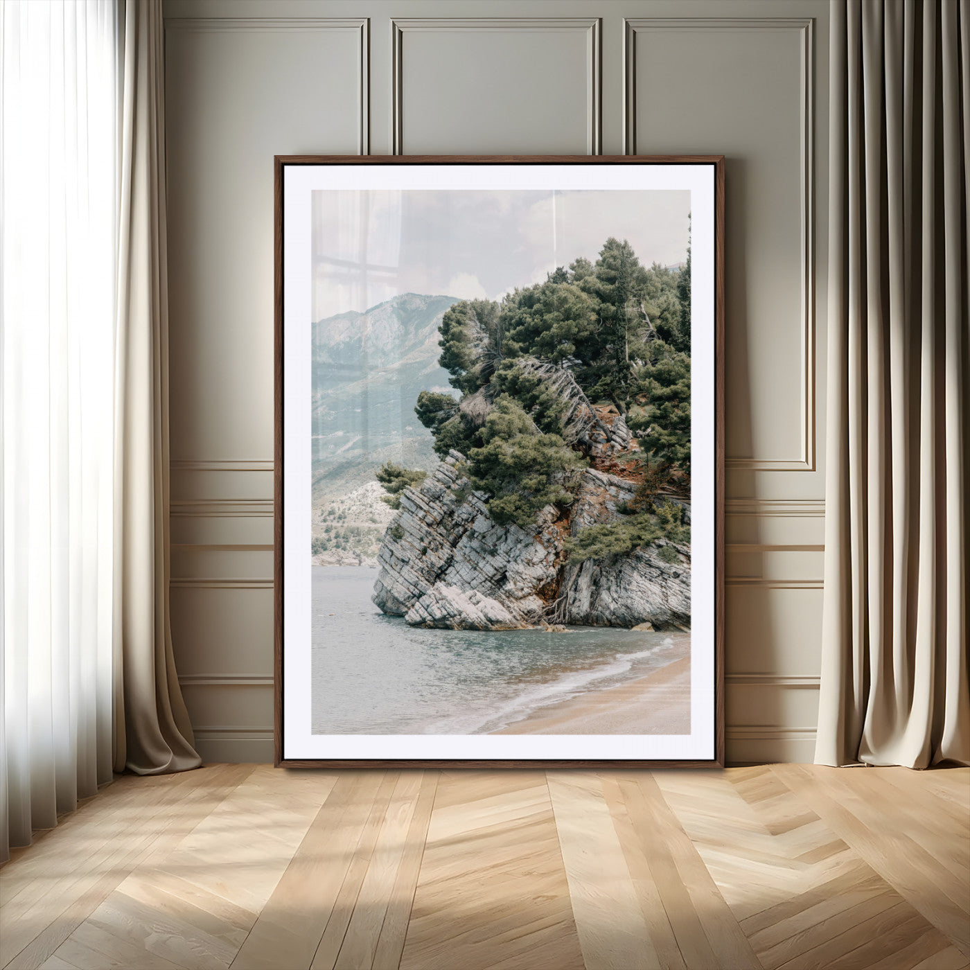 Framed photo of a rocky coastal cliff with dense greenery and calm shoreline, ideal for rustic coastal or earthy-toned home decor.