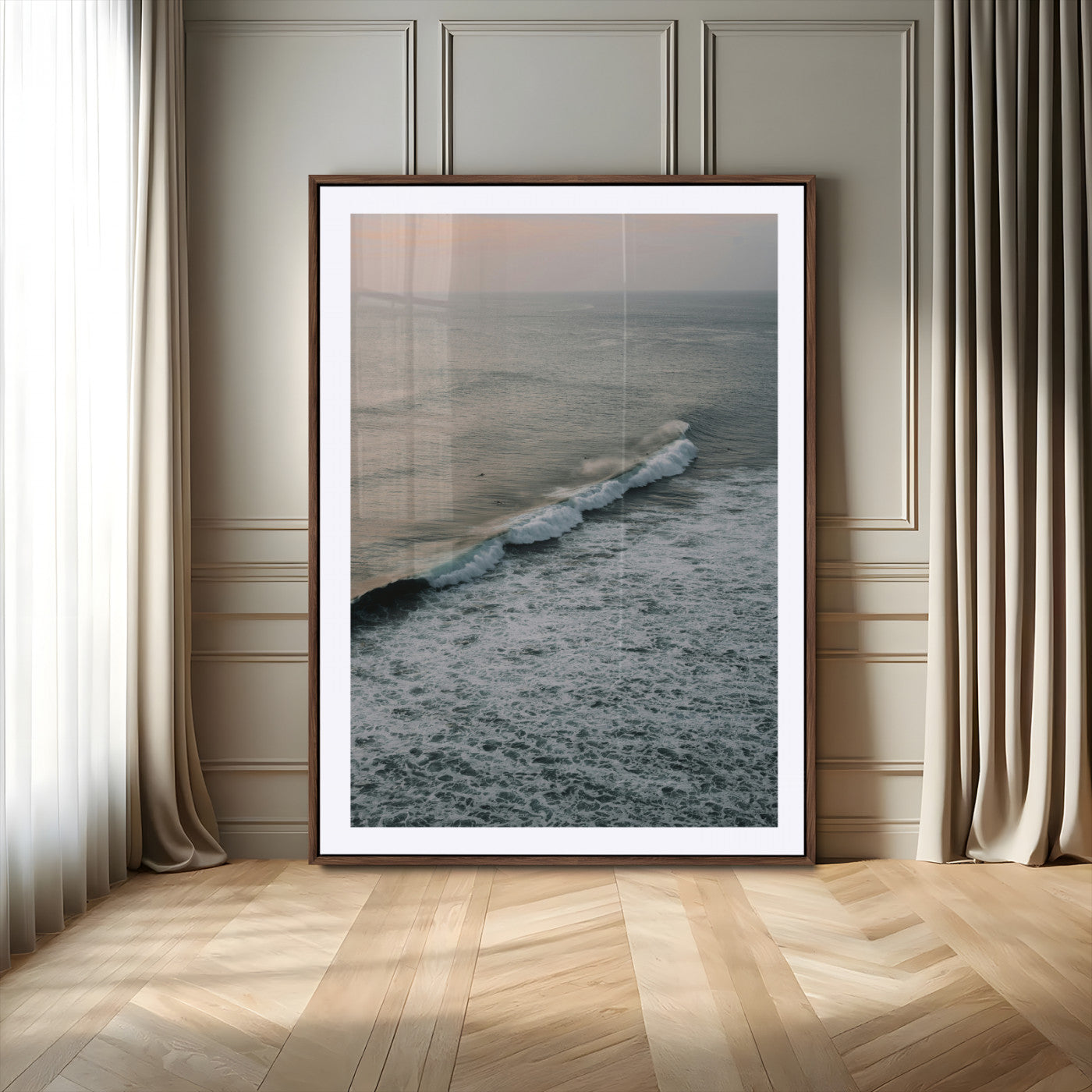 Aerial view of ocean waves rolling towards the shore under a soft sunset sky, creating a peaceful and minimalist coastal scene.