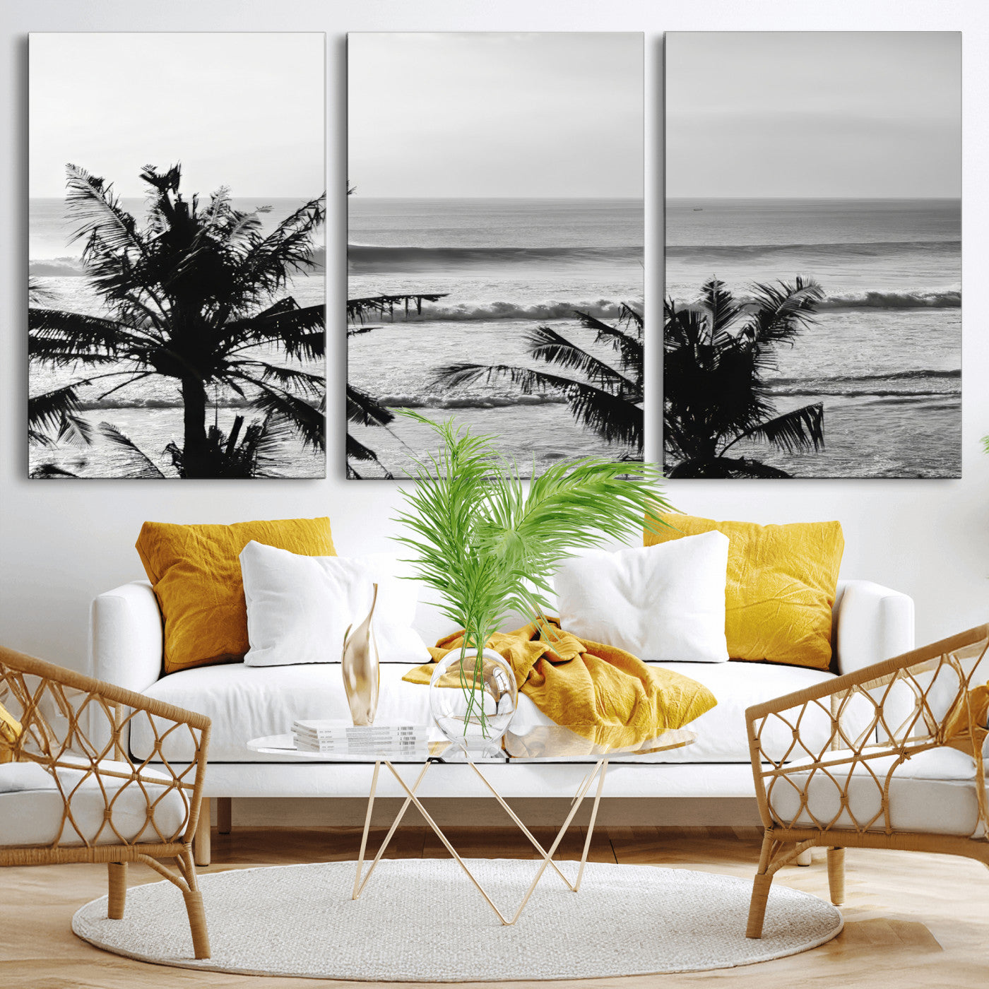 Black and white view of ocean waves crashing on a tropical coastline, framed by silhouetted palm trees under a vast, open sky.